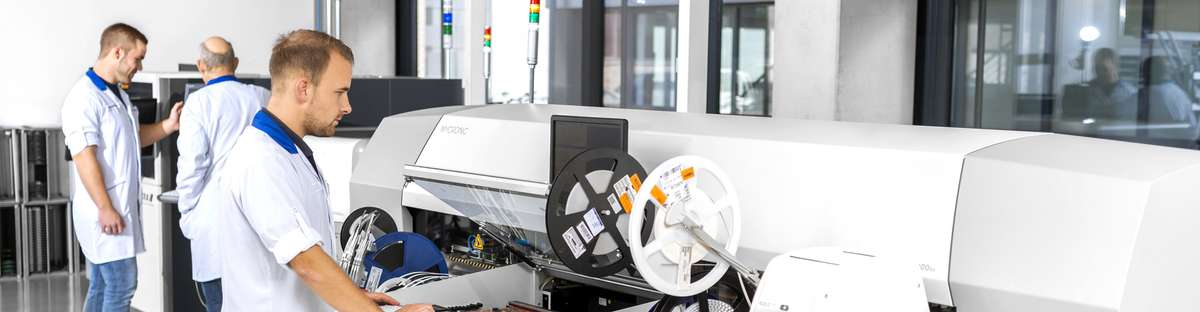 Mitarbeiter an den Maschinen in der Elektronikfabrik.