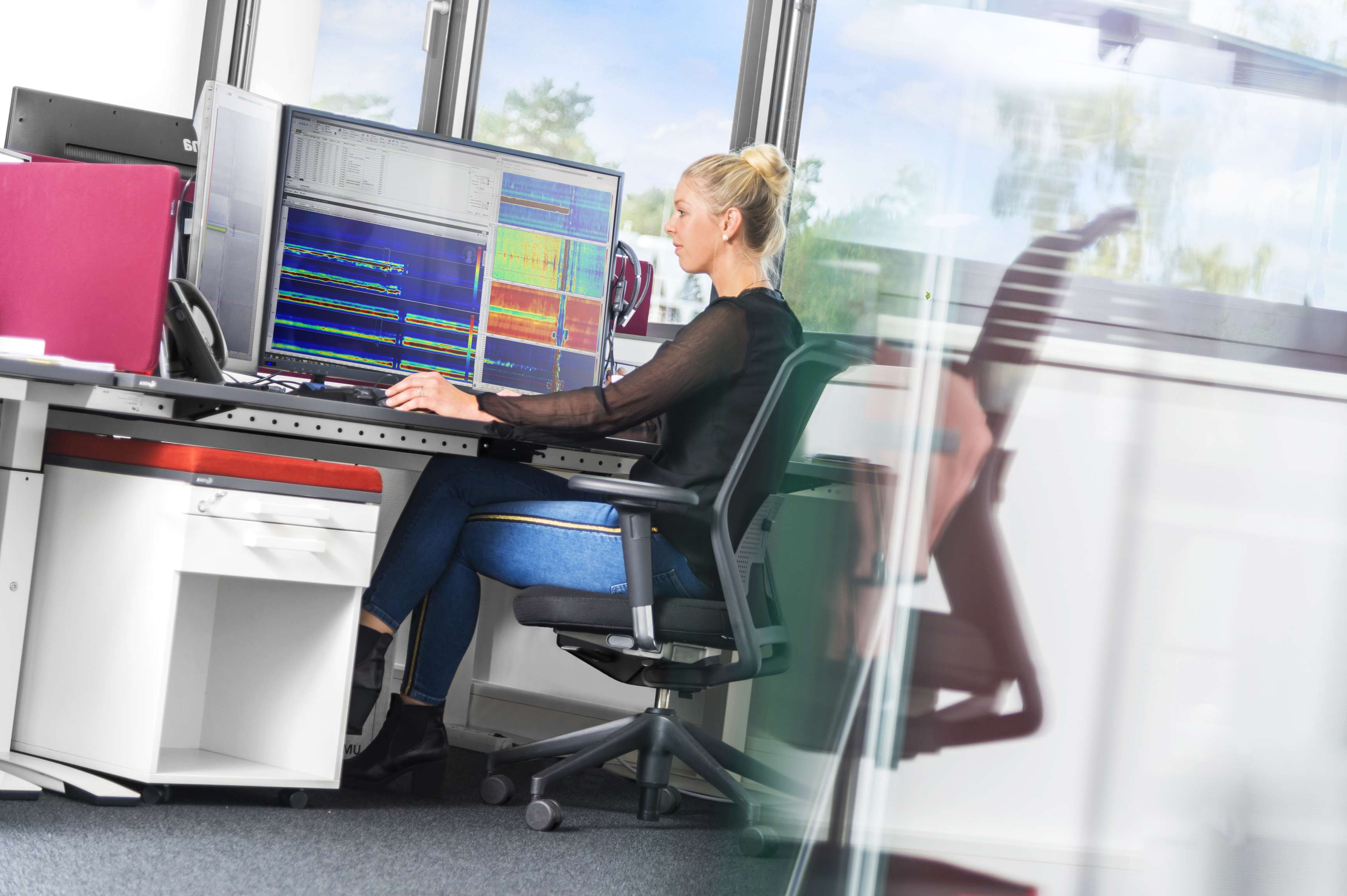 Woman in an office doing data evaluation on a computer.