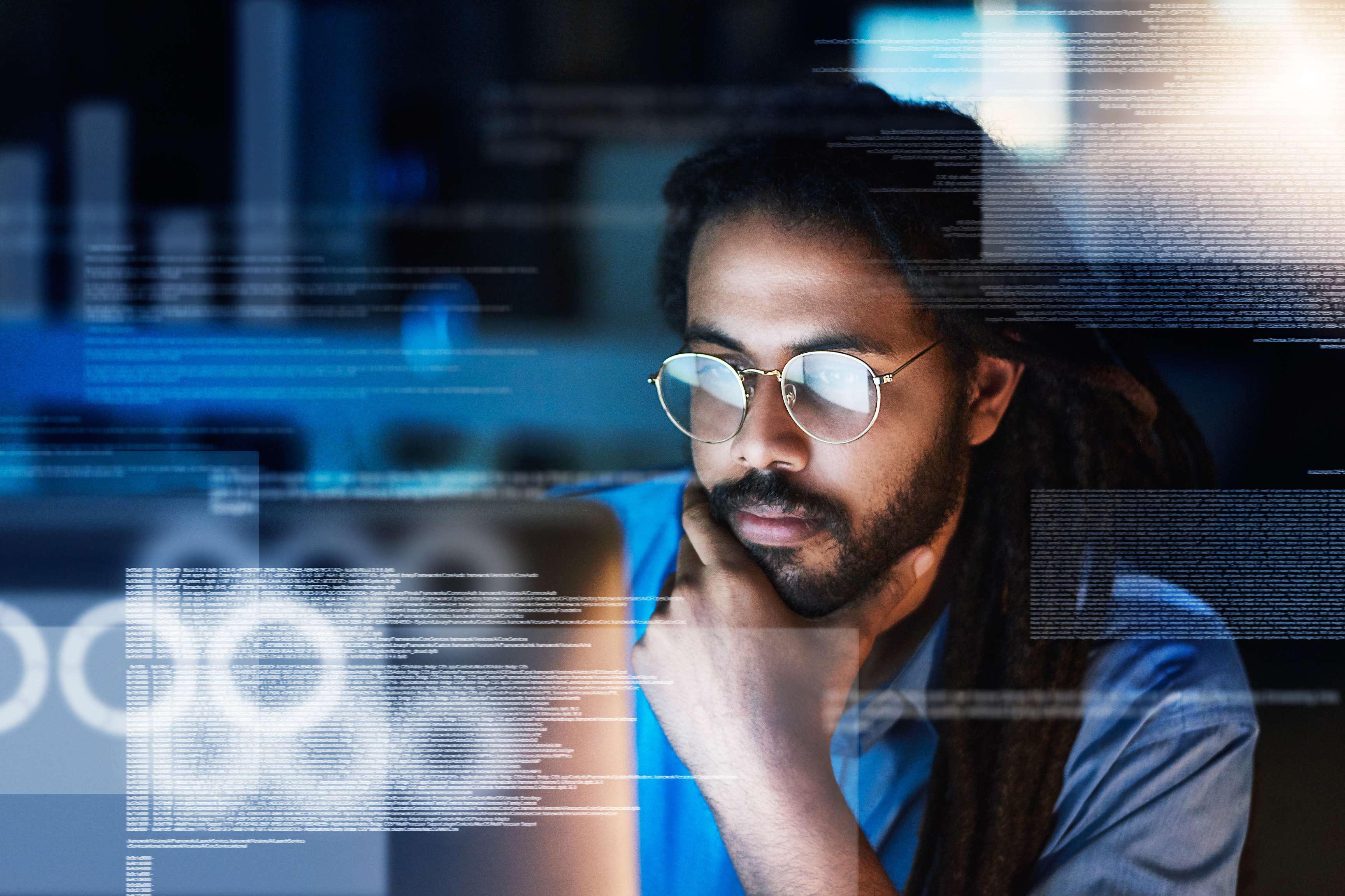 Man wearing glasses looking at screens