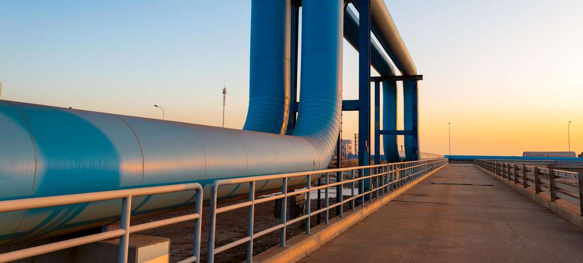 Image of above ground large diameter facility piping in an upside down u form.