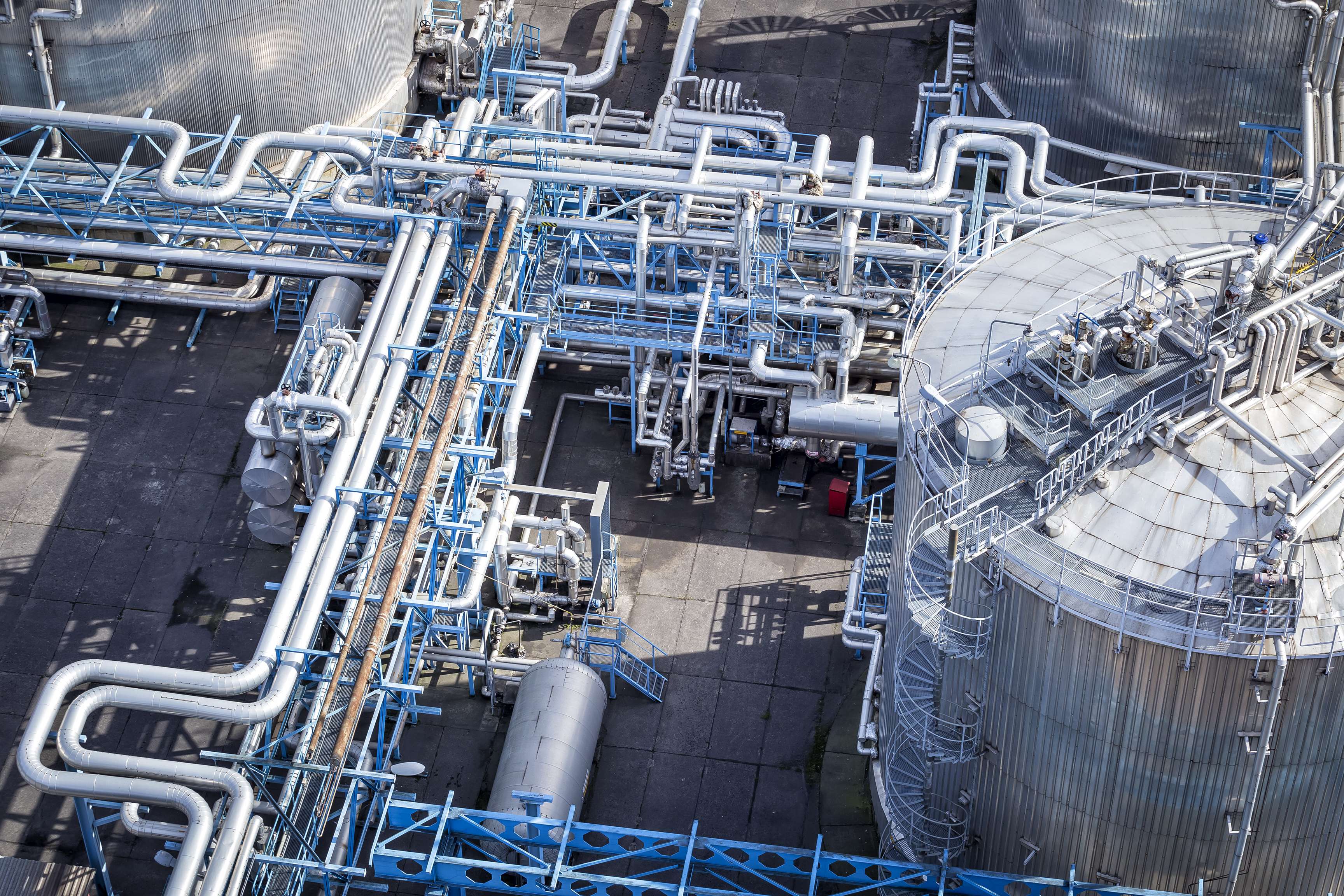 Bird's eye view of a blue-gray piping system and a tank on the right side.