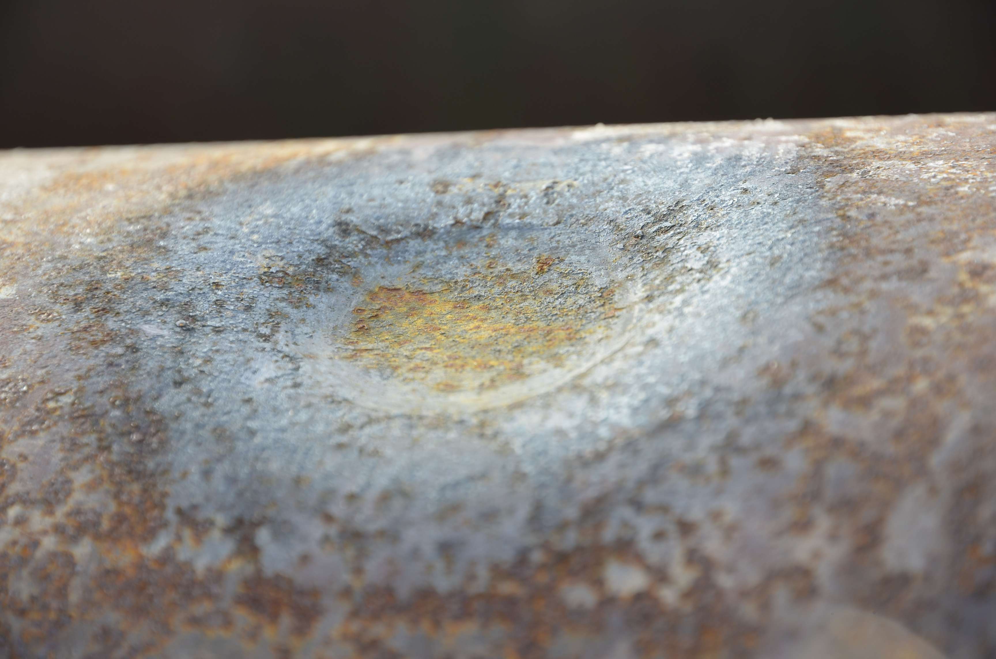 Close up of a dent in the surface of a pipeline.