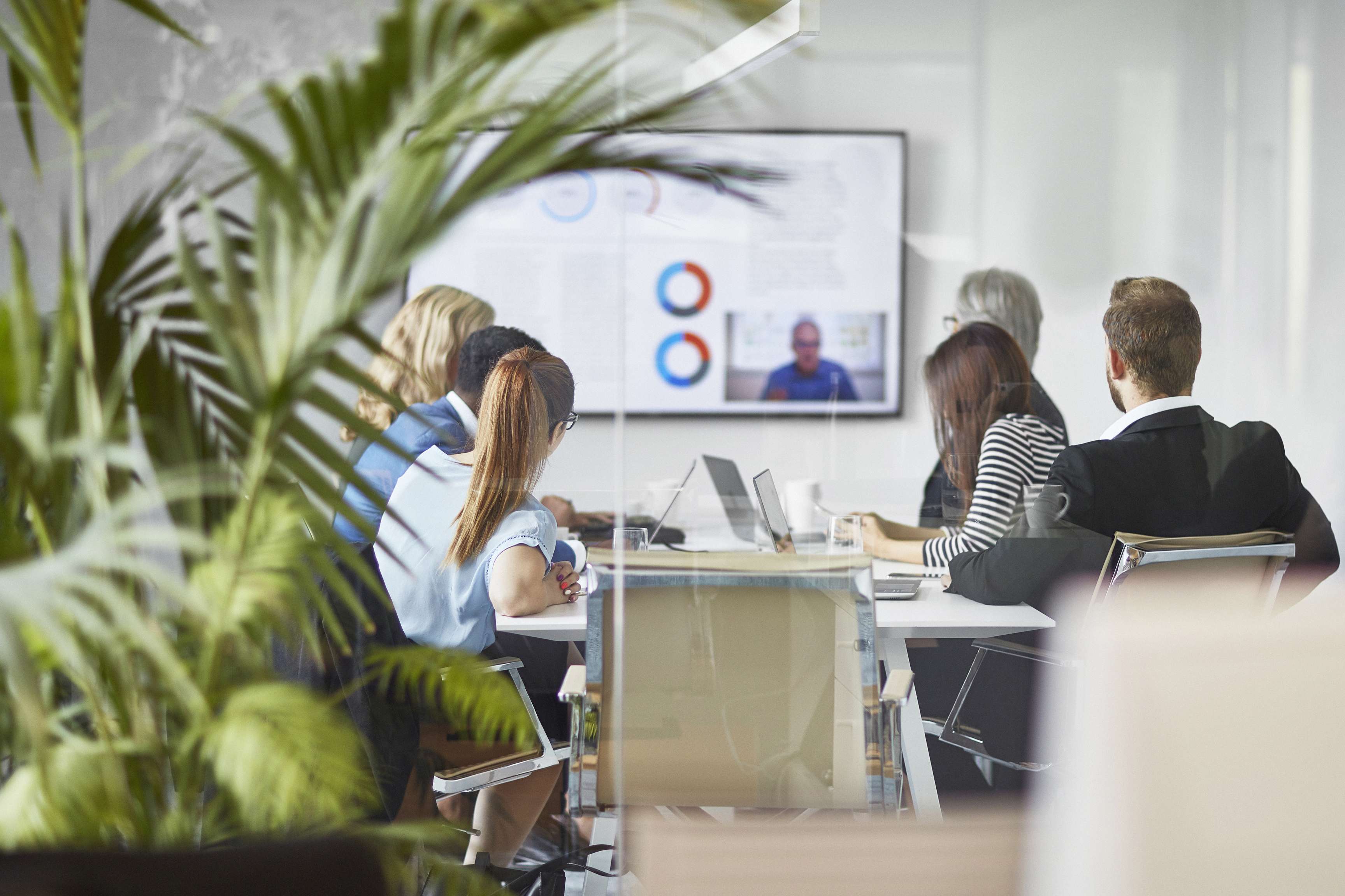 Several employees in a conference room looking at whiteboard.