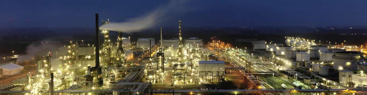 Picture of a refinery site in the dark on which numerous lights shine.