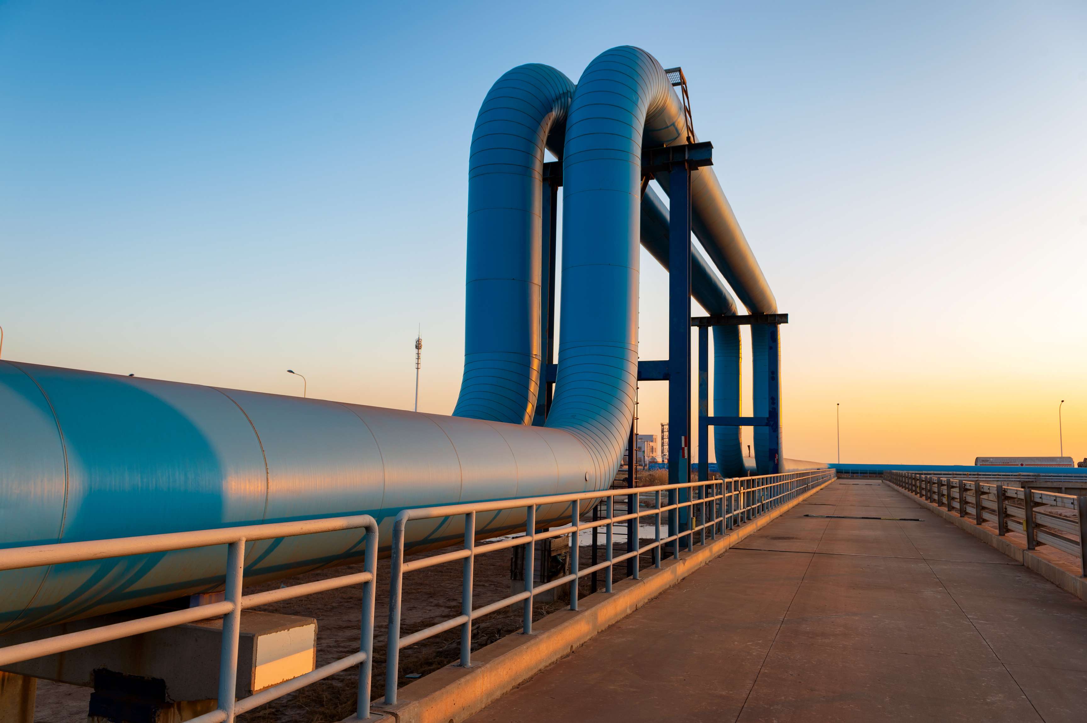 Image of above ground large diameter facility piping in an upside down u form.