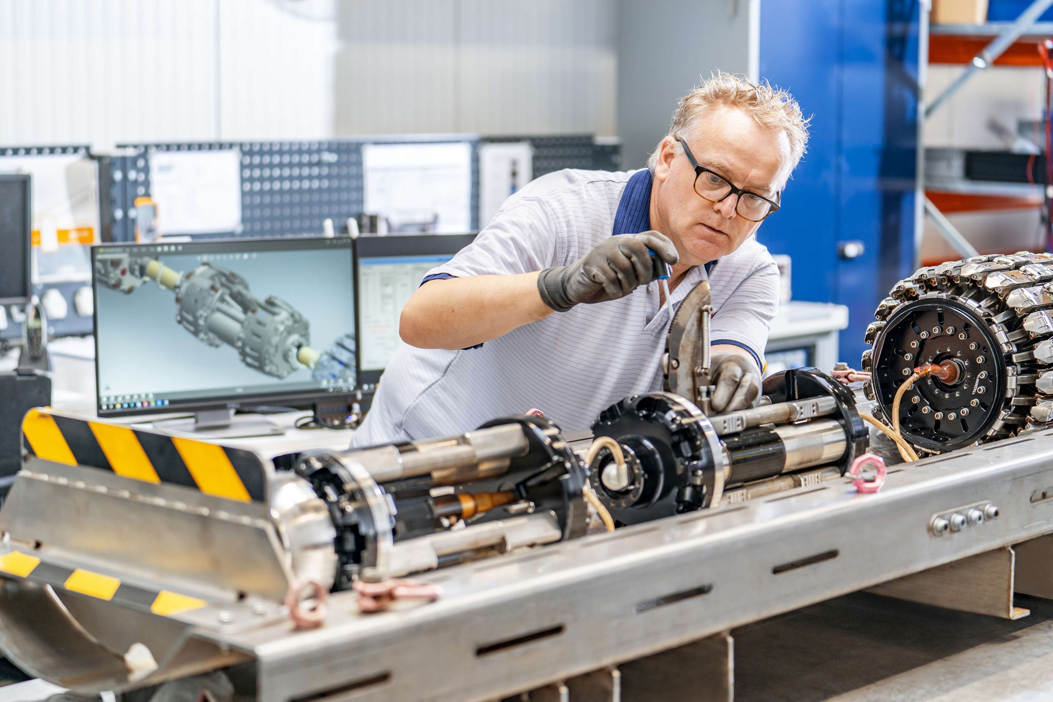 Ein ROSEN Mitarbeiter arbeitet in der Werkstatt und baut ein Tool mit filigranen Bewegungen zusammen.