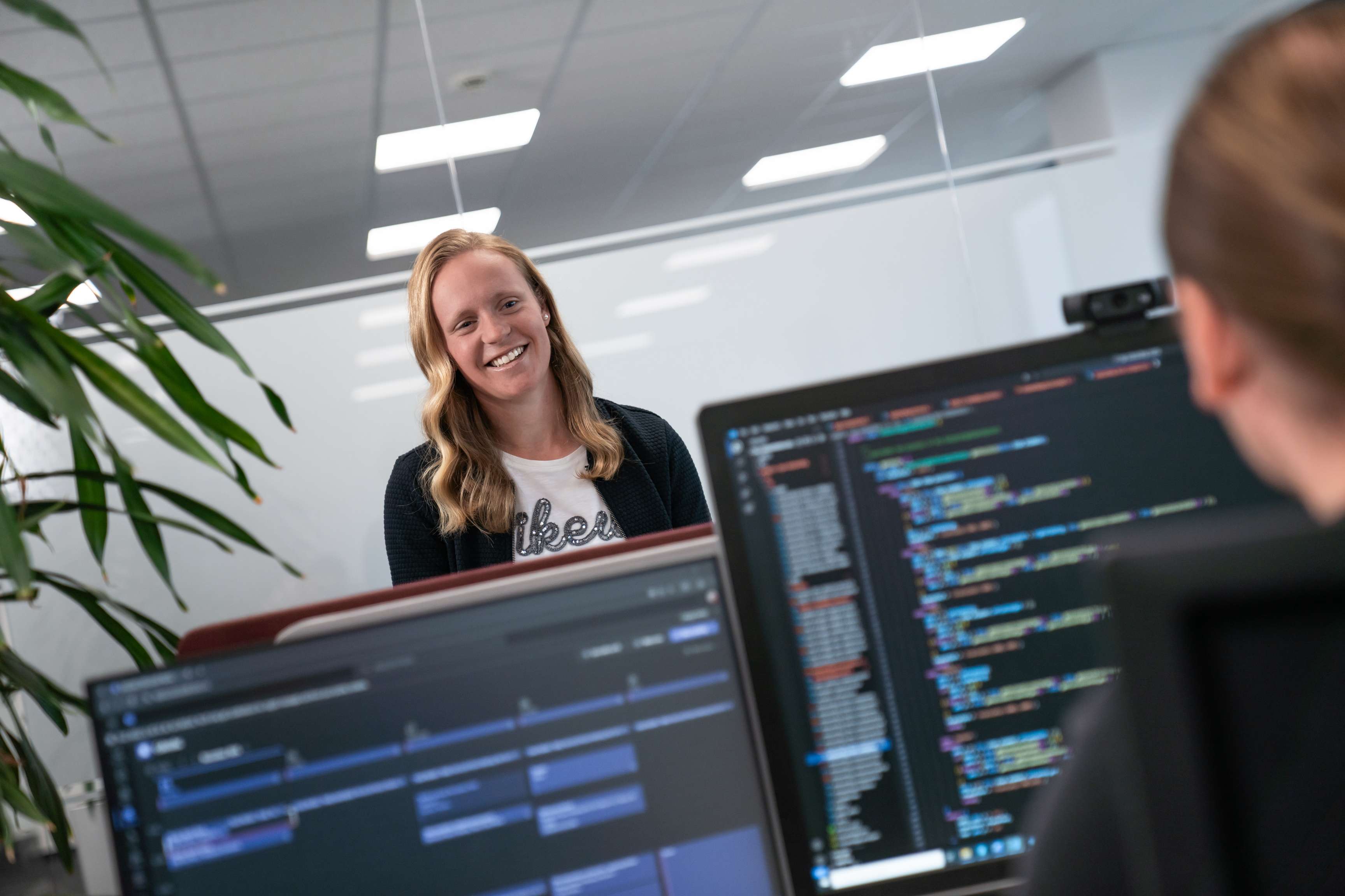 ROSEN-Kollegen in einem Büro, die vor Bildschirmen sitzen oder stehen.