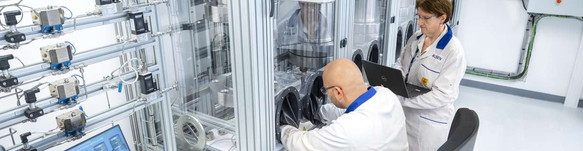 Two employees in ROSEN's hydrogen lab work at a testing booth.