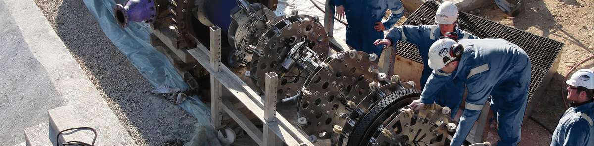 Part of a tool on a transport rack with a worker bending over it.