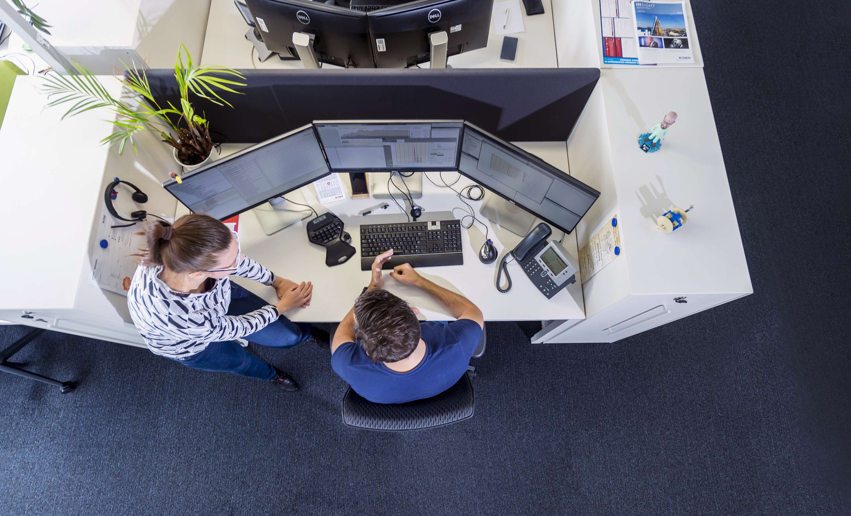 Ein Schreibtisch in einem Büroraum, fotografiert aus der Vogelperspektive.