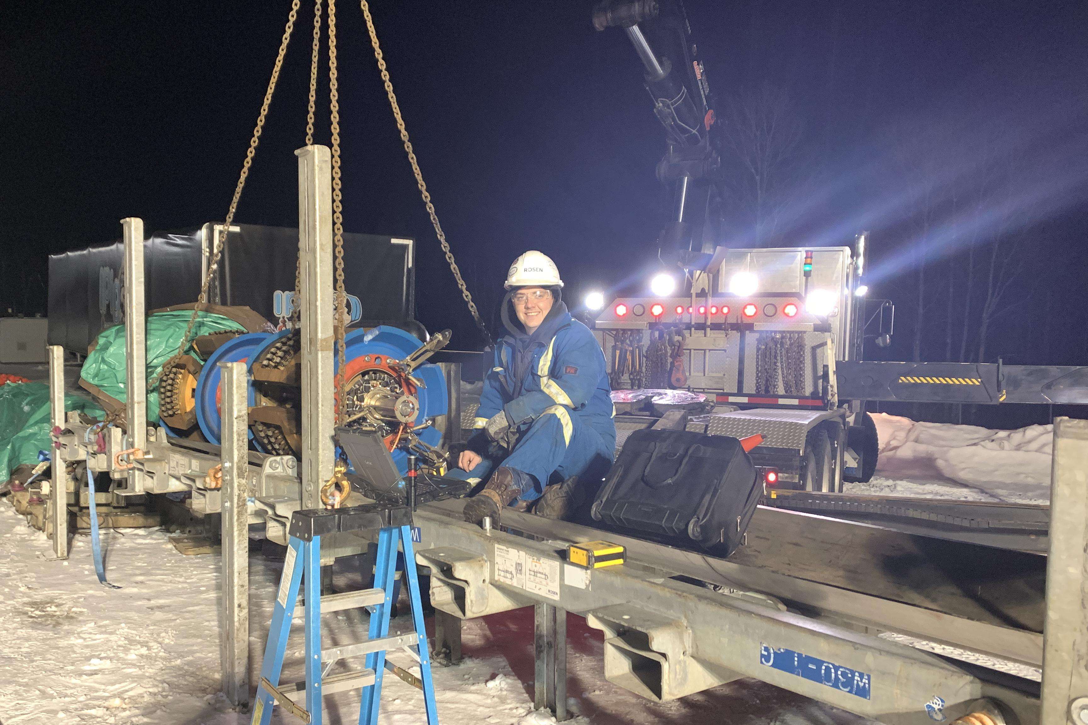 A man on site next to an in-line inspection tool.