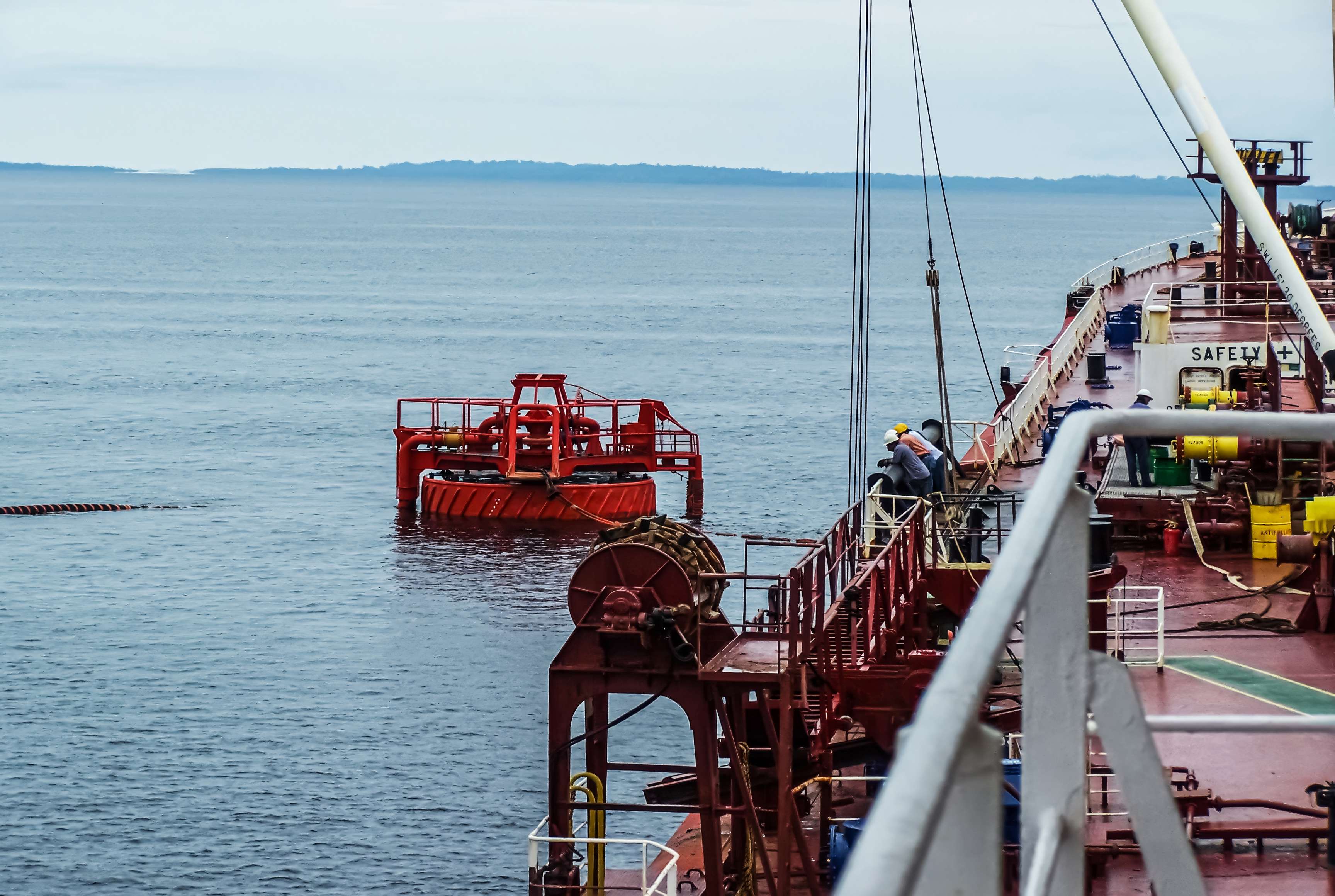 Picture of an offshore oil loading process from a single buoy mooring into an oil tanker.