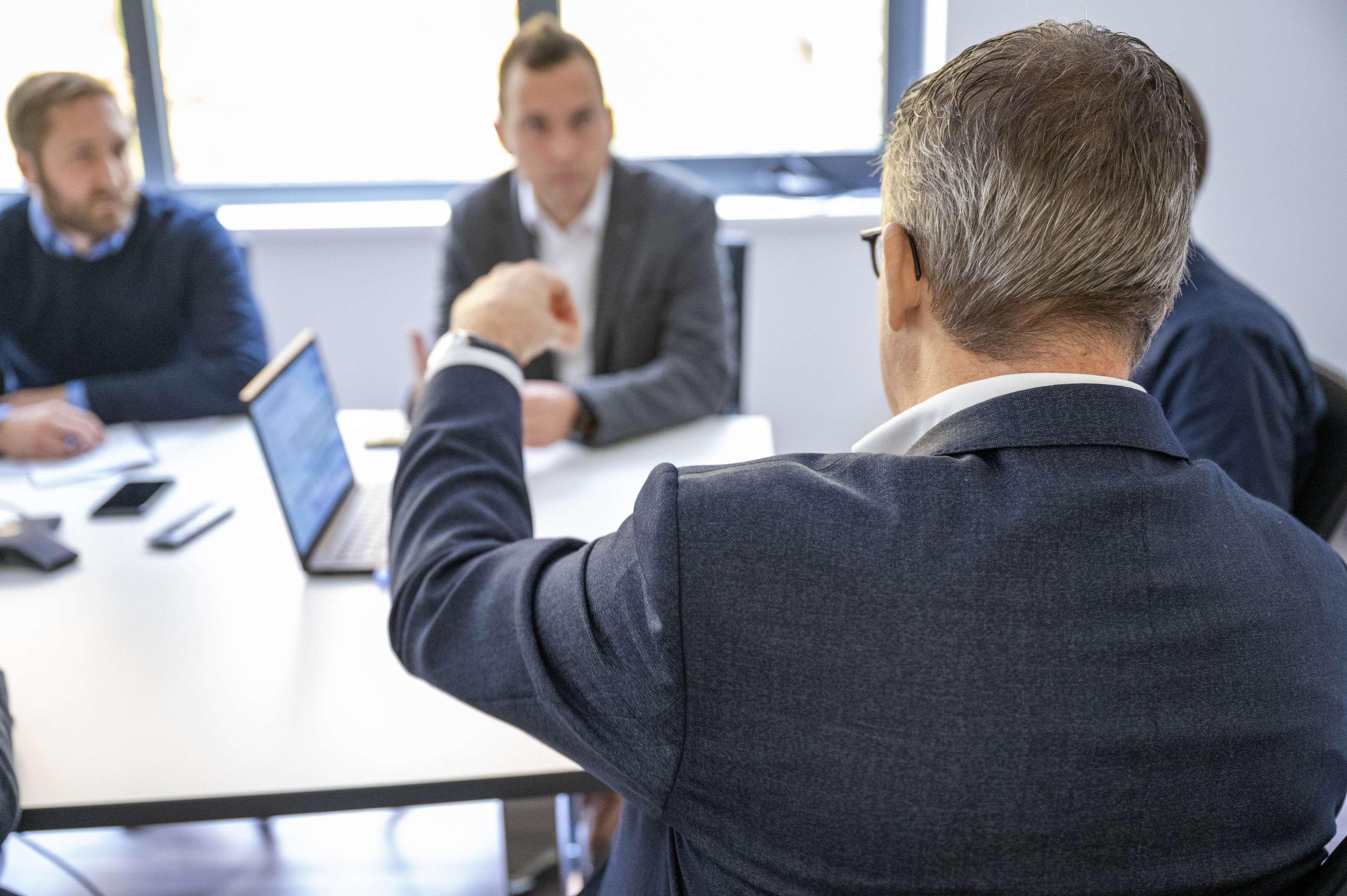 Several employees at a meeting talking to each other.