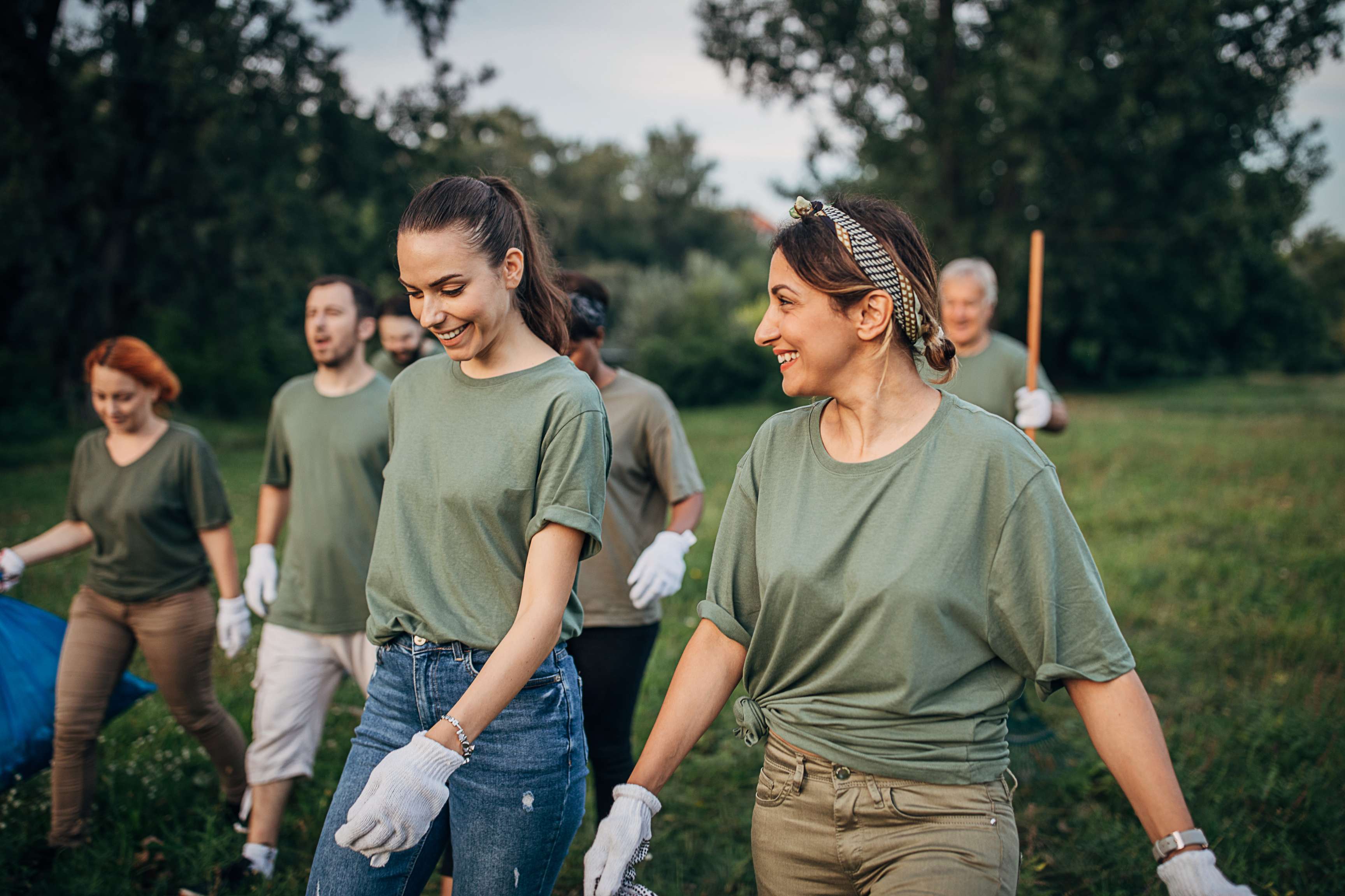 Multi-ethnic group of people, environmental volunteers, collecting garbage from the public park.