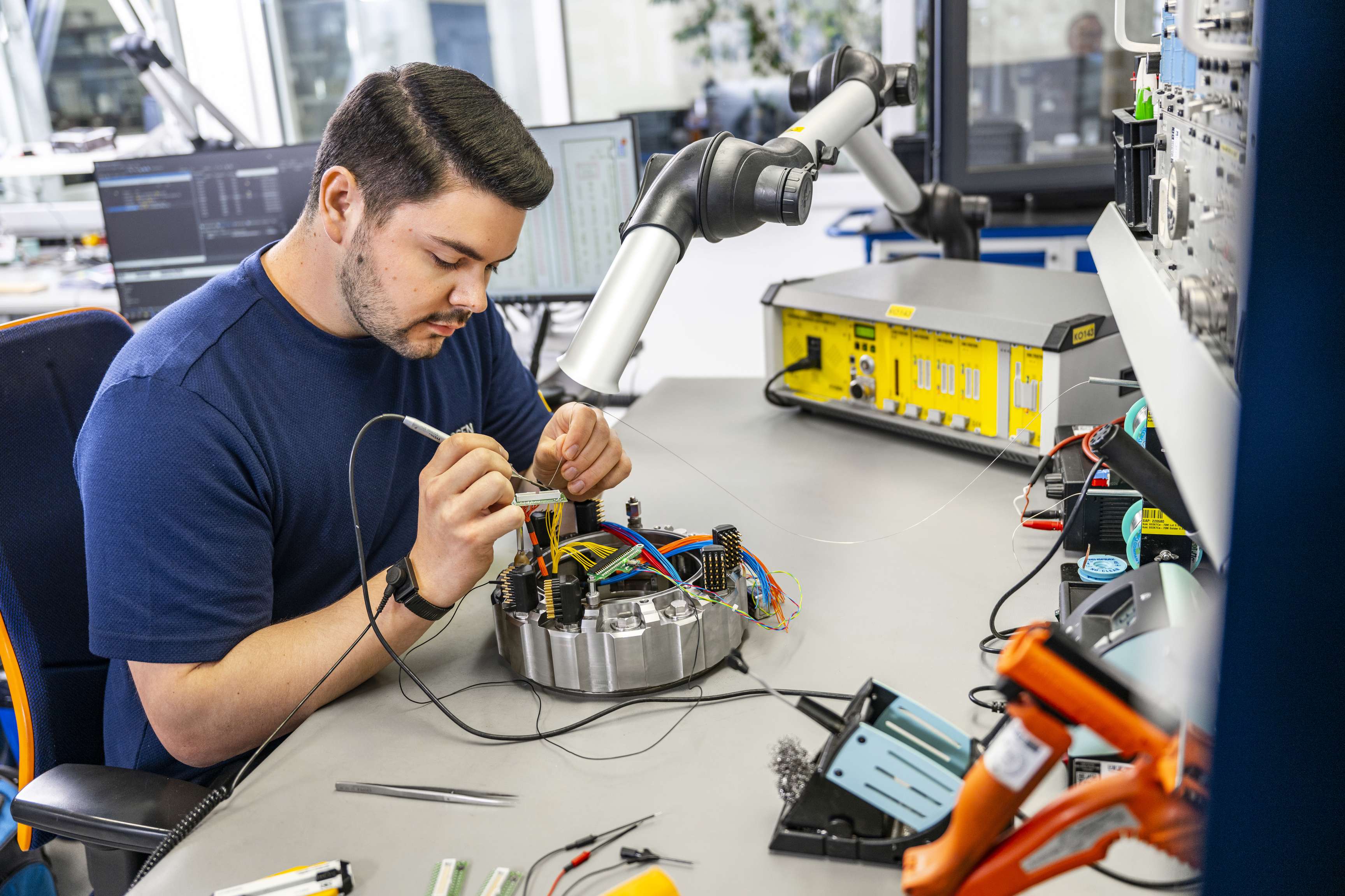 Ein Mann, der sich auf das Löten von Teilen konzentriert.
