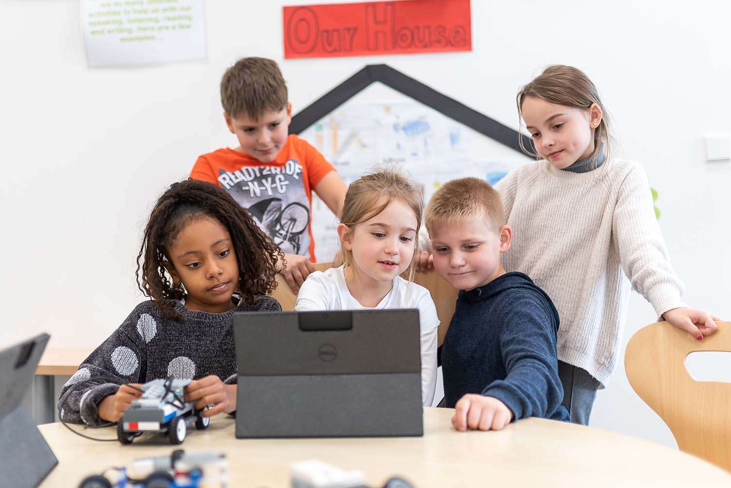 A few school kids in front of a tablet