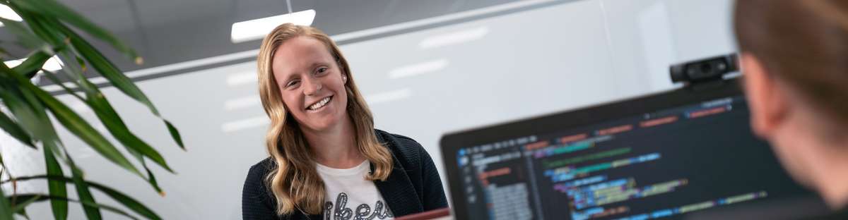 ROSEN-Kollegen in einem Büro, die vor Bildschirmen sitzen oder stehen.