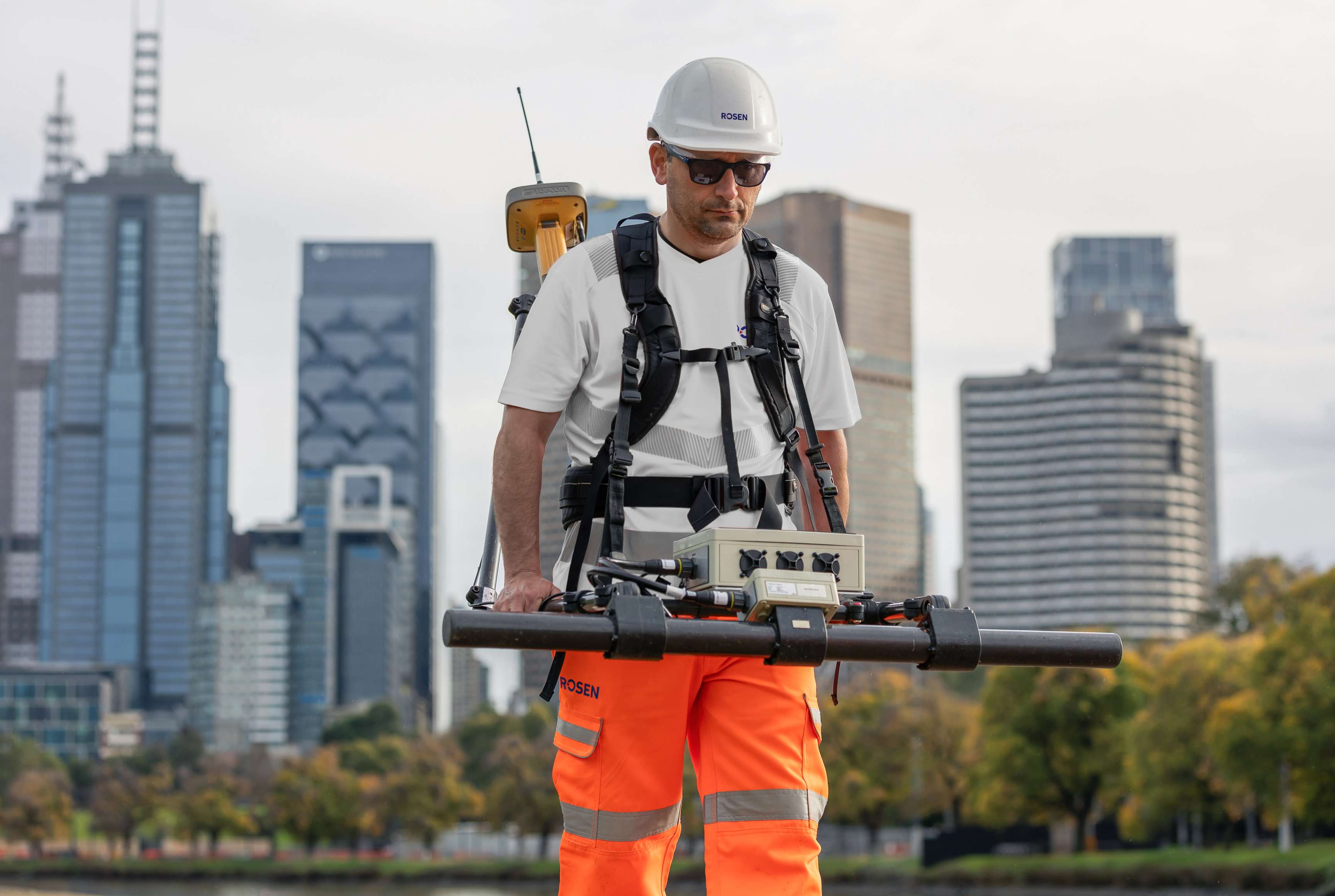 ROSEN employee is doing a Large Stan-Off Magnetometry (LM) measurement in front of a skyline.