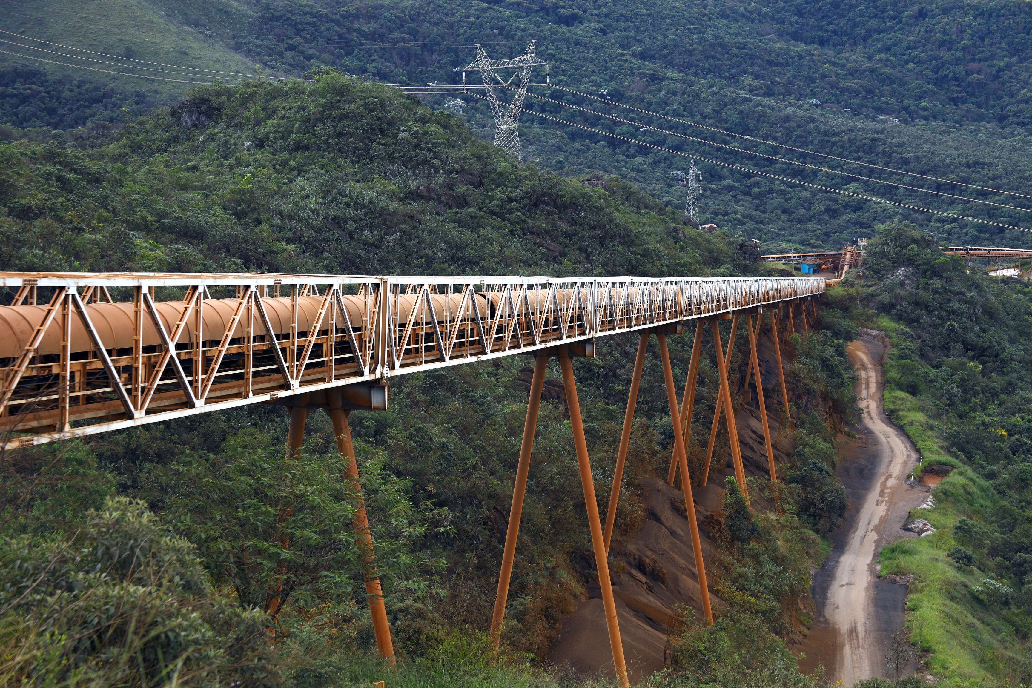 Pipeline leads over a high bridge in mountainous terrain.