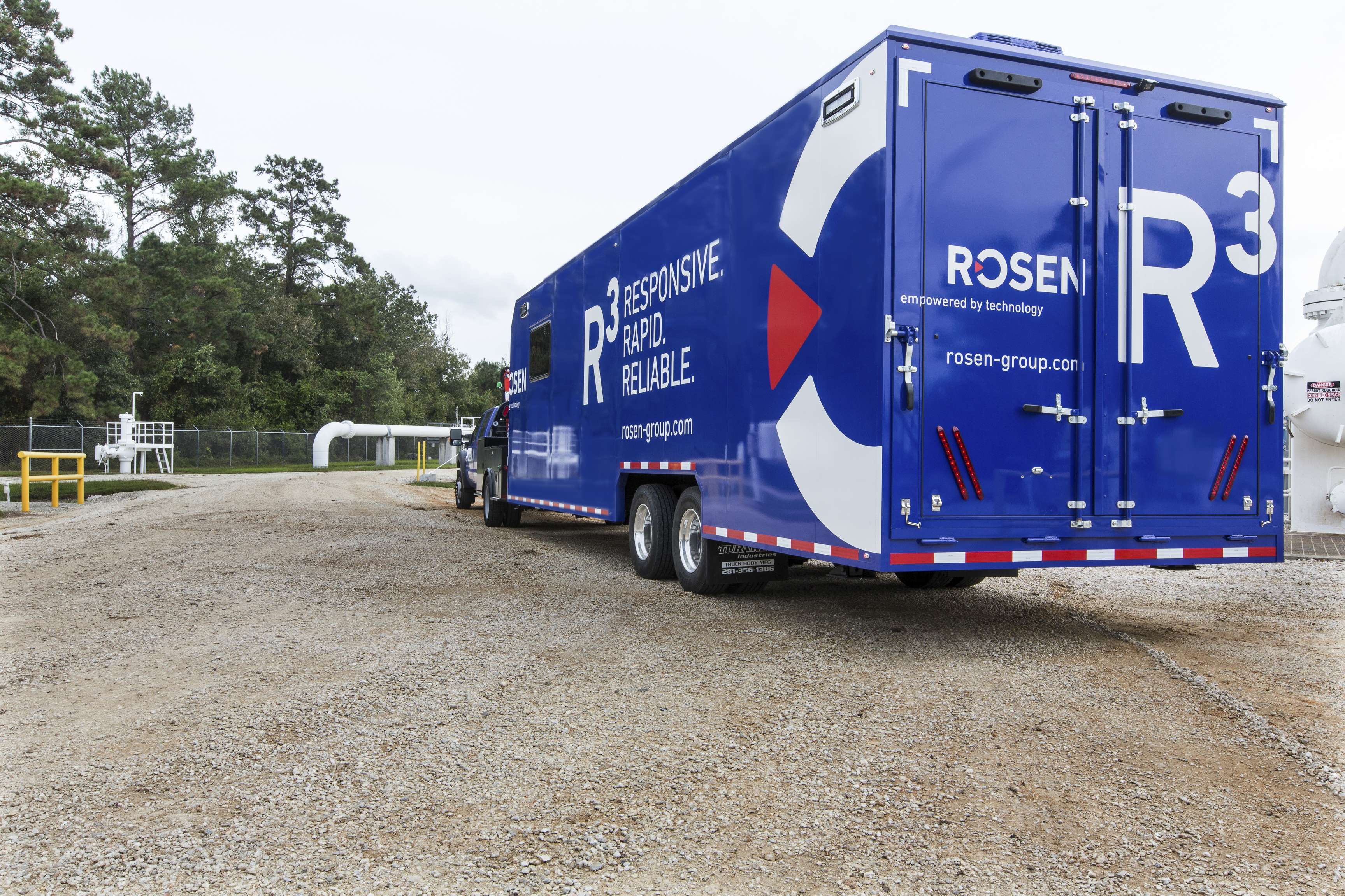 Blue mobile diagnostics unit (truck and trailer) on site.
