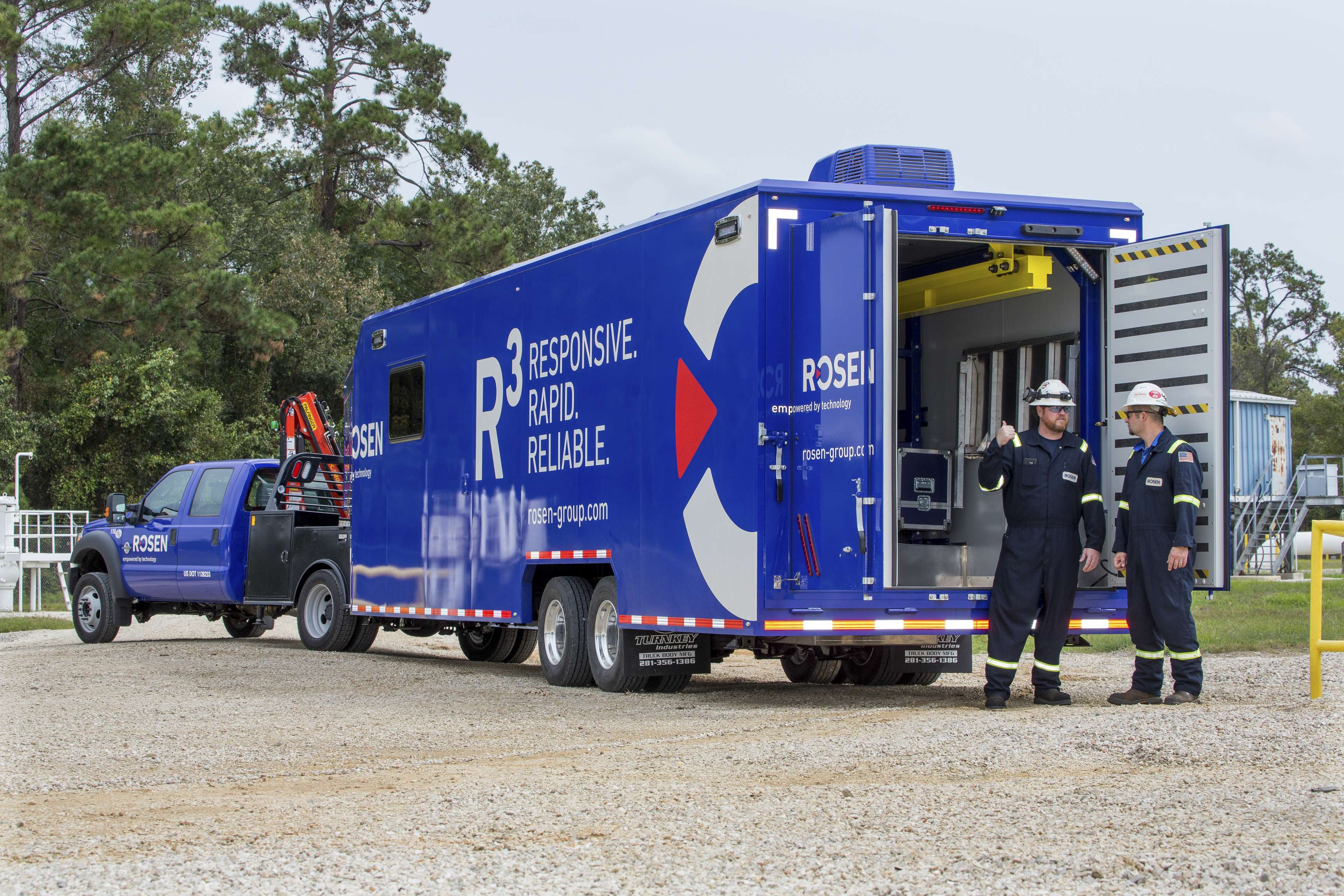 Blue R³ truck and trailer with two technicians.