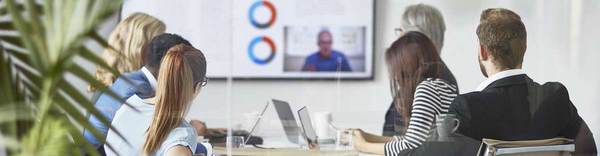 Several employees in a conference room looking at whiteboard.