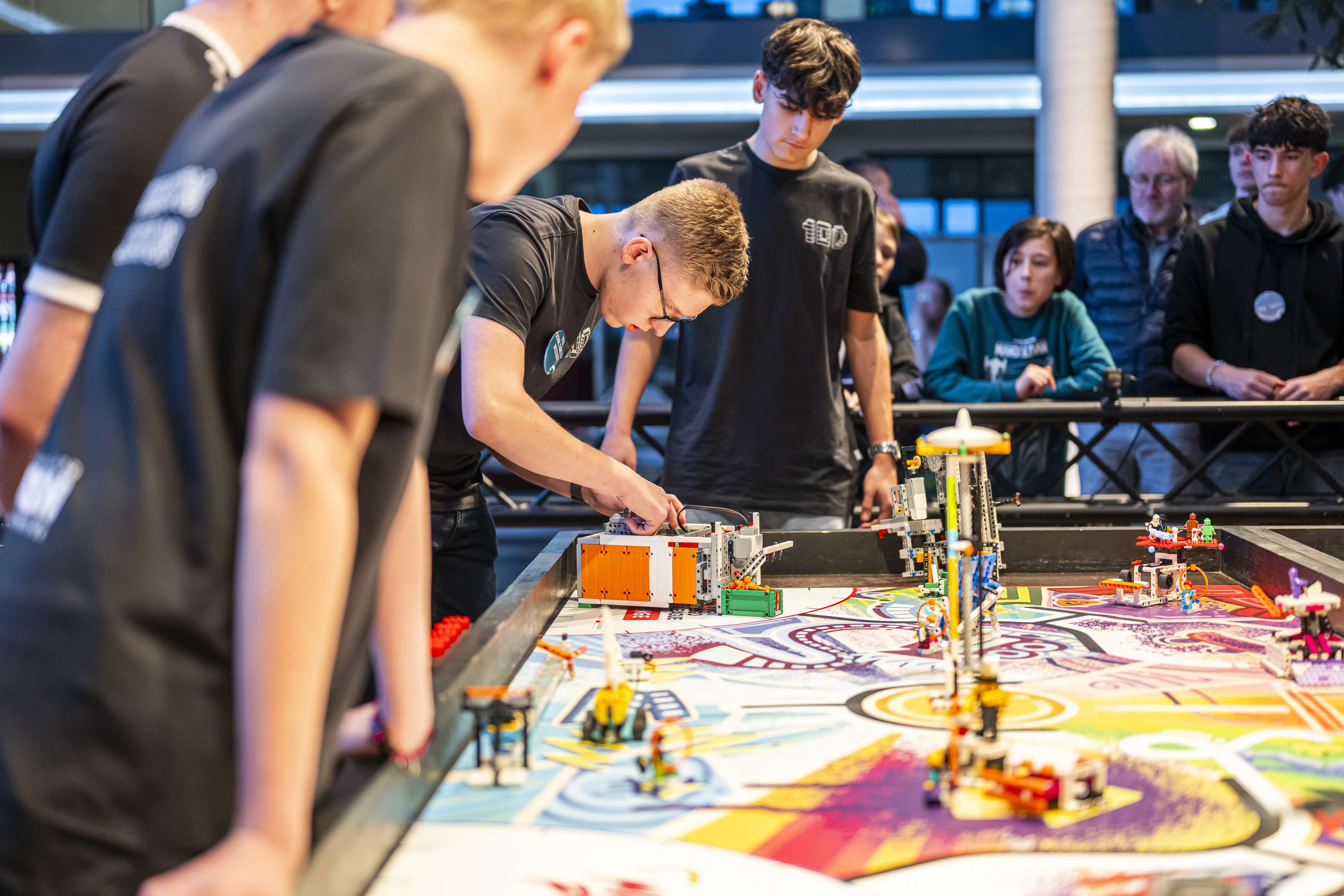 Close-up of some young men and the Lego robots during the Robot Games.