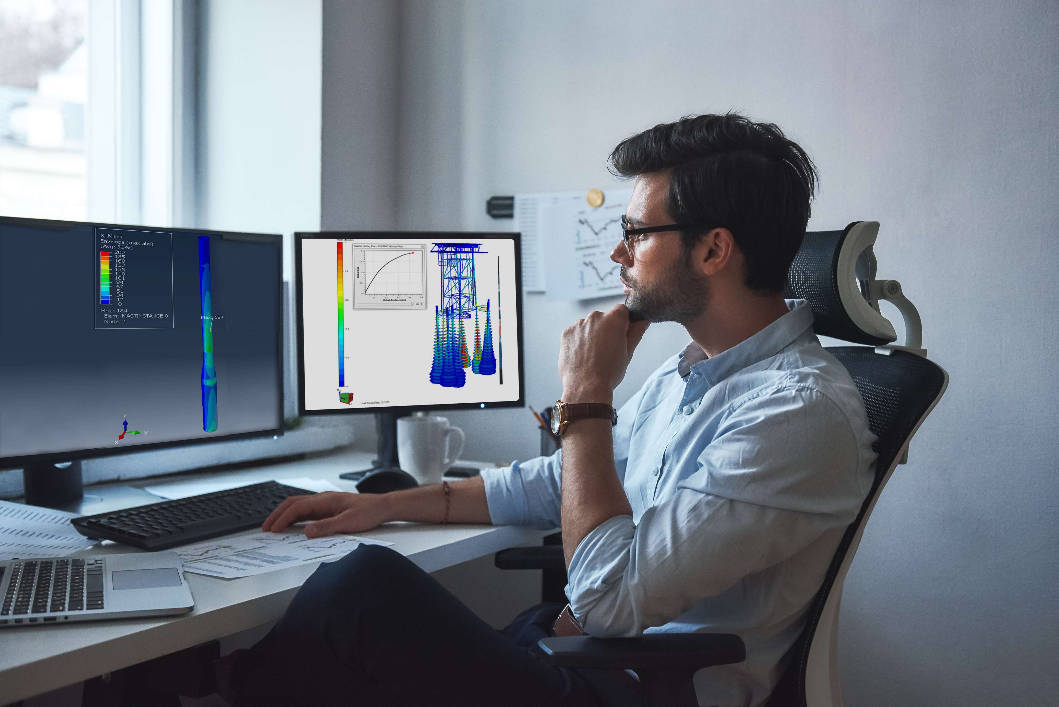 Employee looks at computer screen showing model of offshore facility.