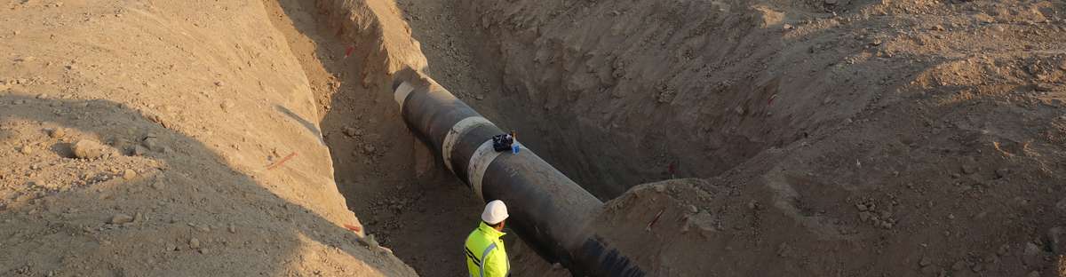 ROSEN field verification technicians standing in front of an excavated pipeline.