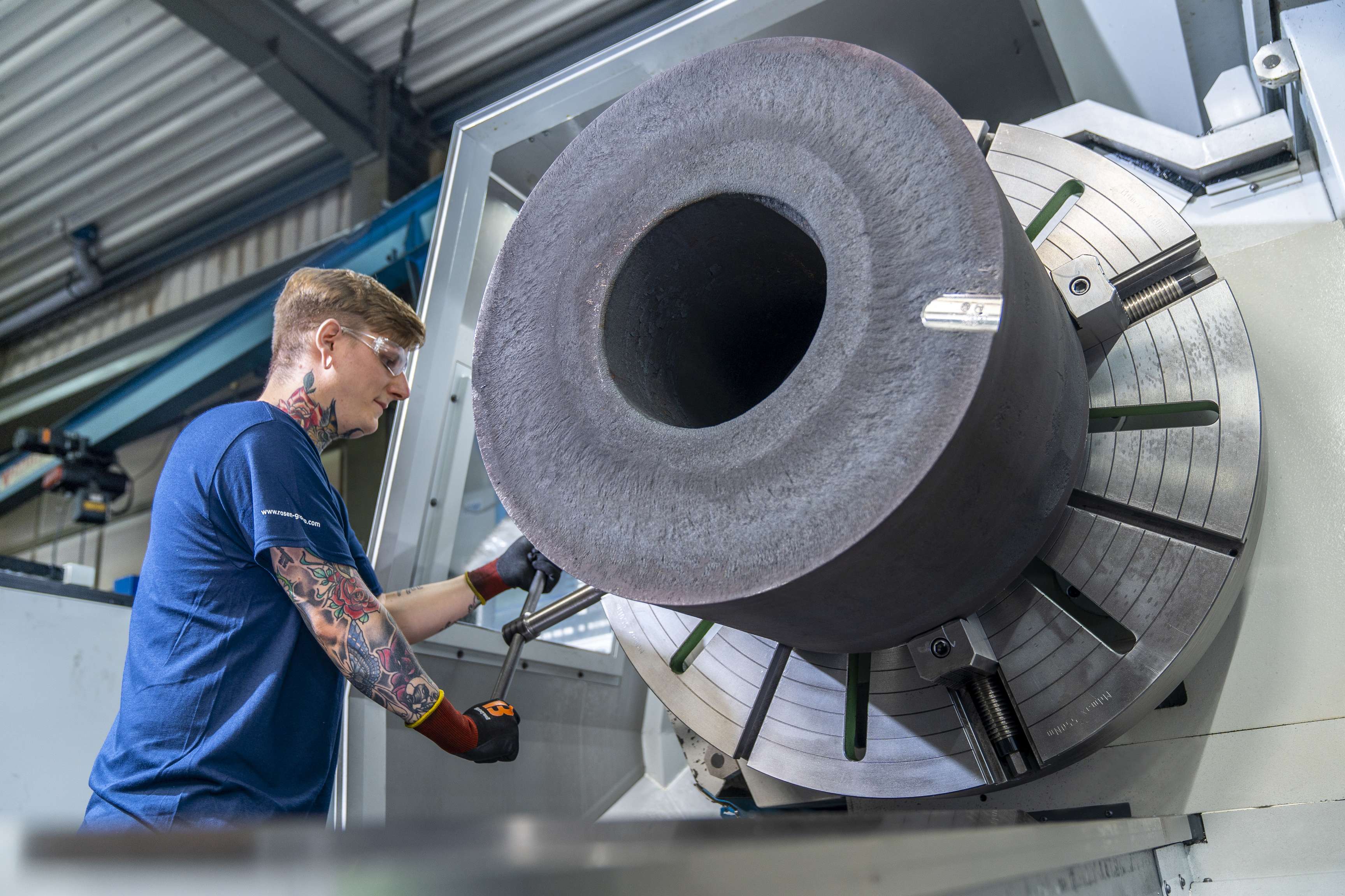 Ein junger ROSEN Mitarbeiter betätigt manuell eine Maschine mit einer Hebelbewegung.