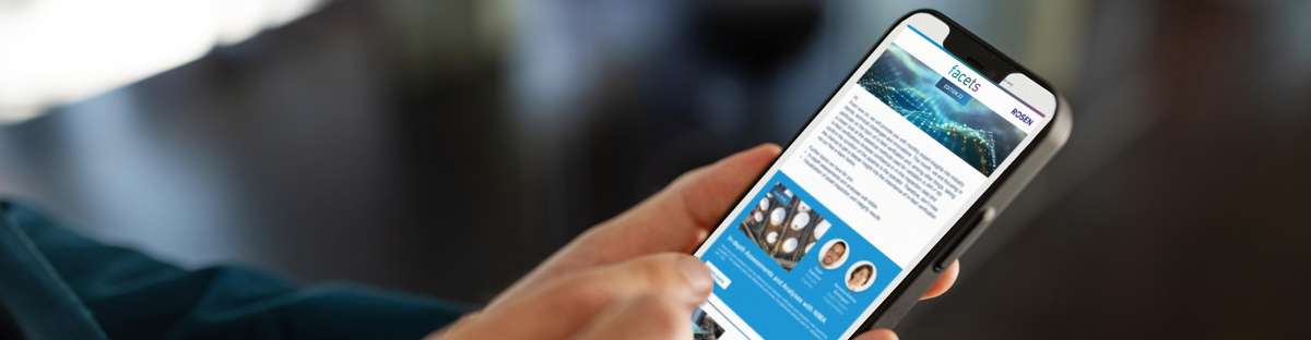 Close up of a hand holding a cell phone on which the facet newsletter can be seen.