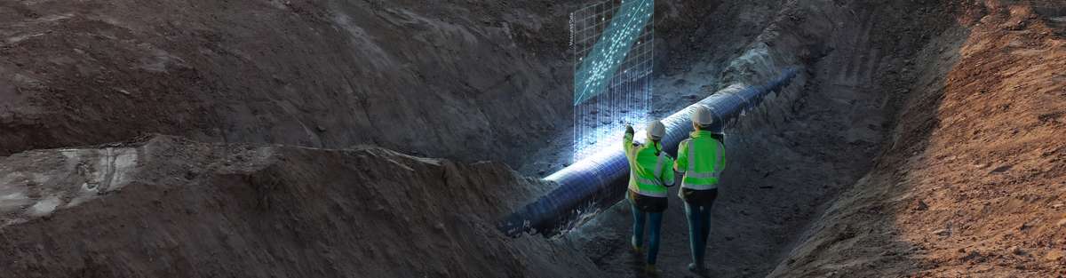 Two persons in safety wear standing in front of a dug out pipeline looking at a virtually created graph with dots.