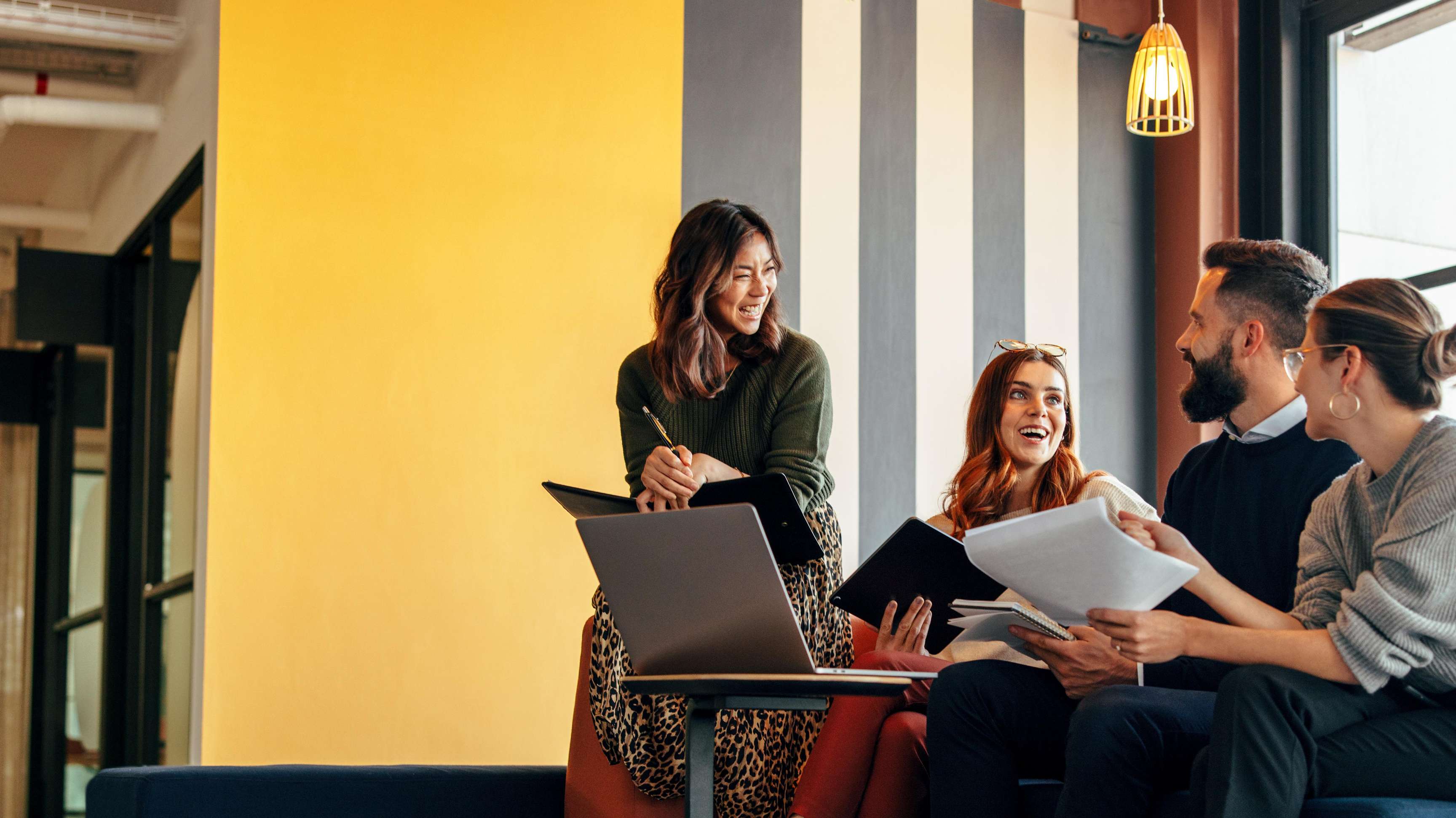 Multicultural business people working in a colorful office lobby.