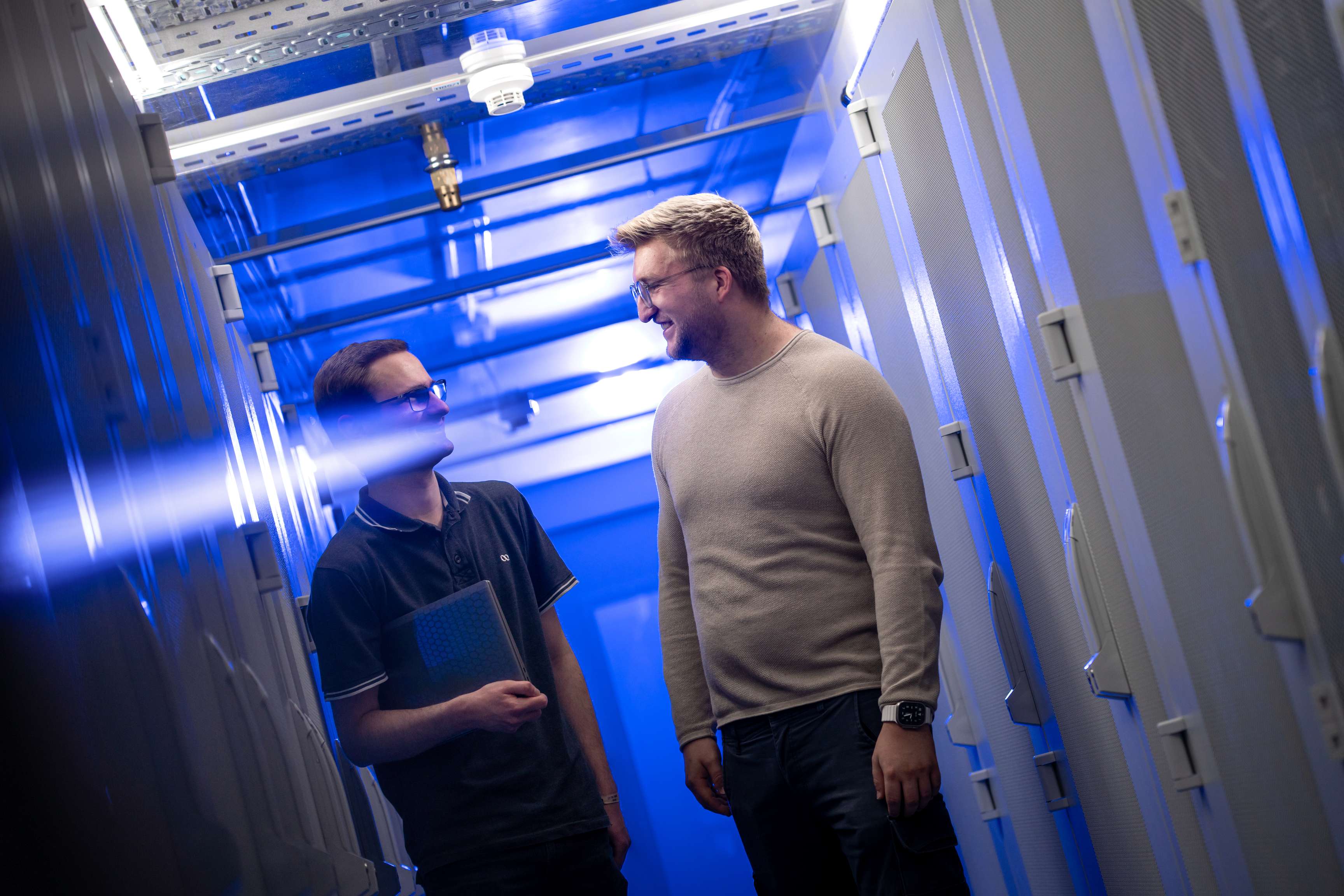 Zwei Männer unterhalten sich in einem Serverraum.