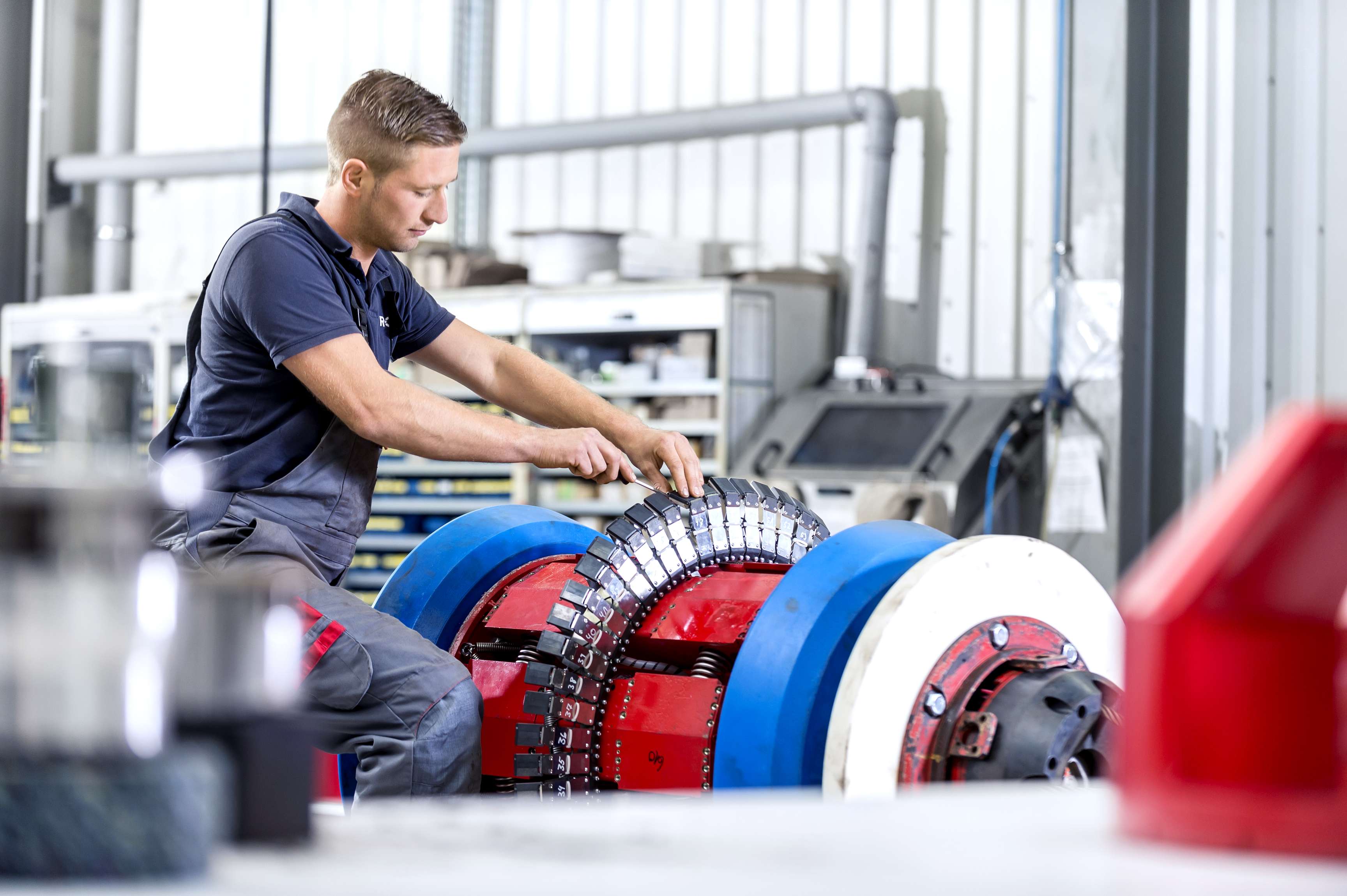 Ein Arbeiter in der Fabrik arbeitet mit einem Schraubenzieher an Werkzeugsensoren.