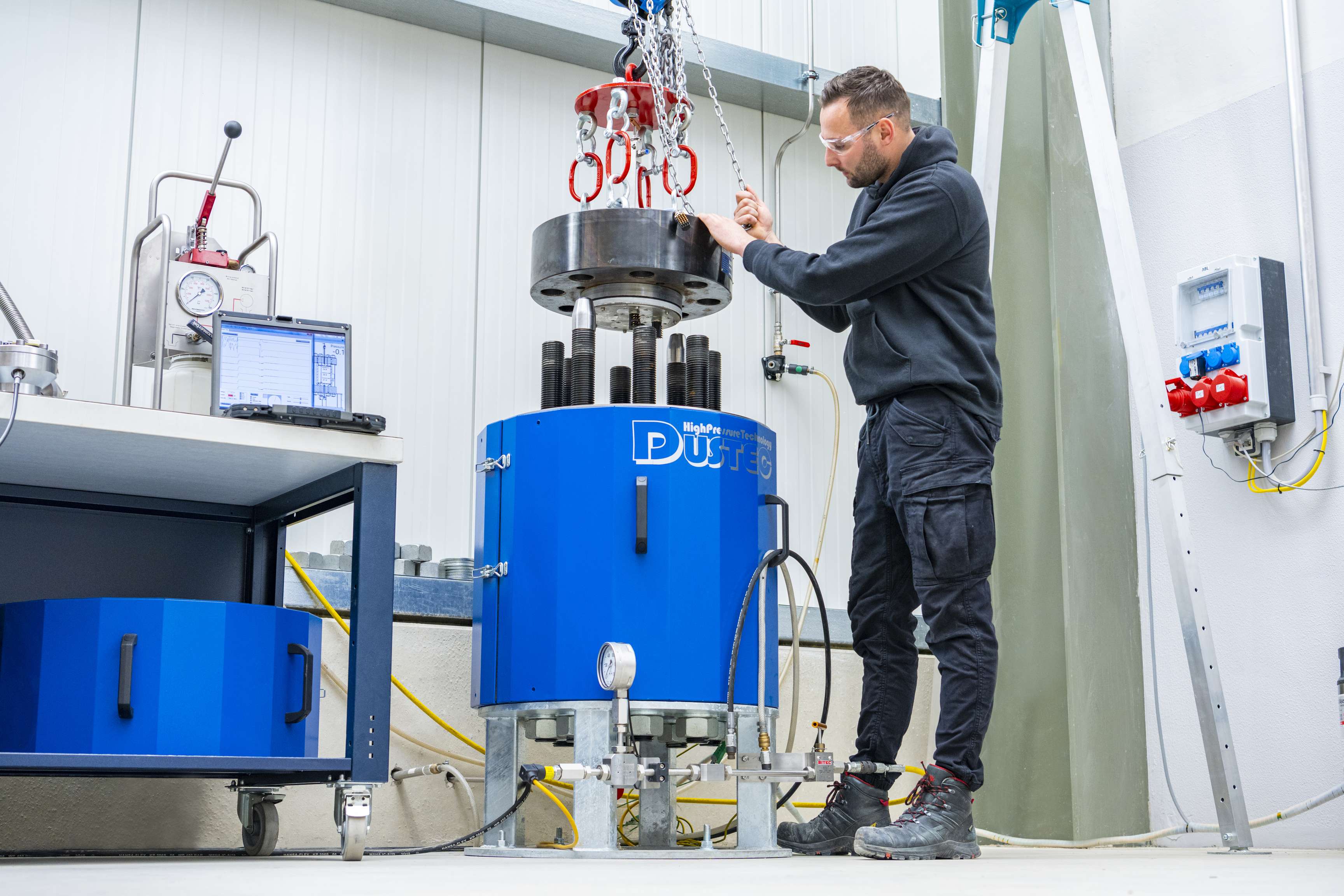 Employee works on high pressure machine in which pipeline parts with smaller diameters are used.