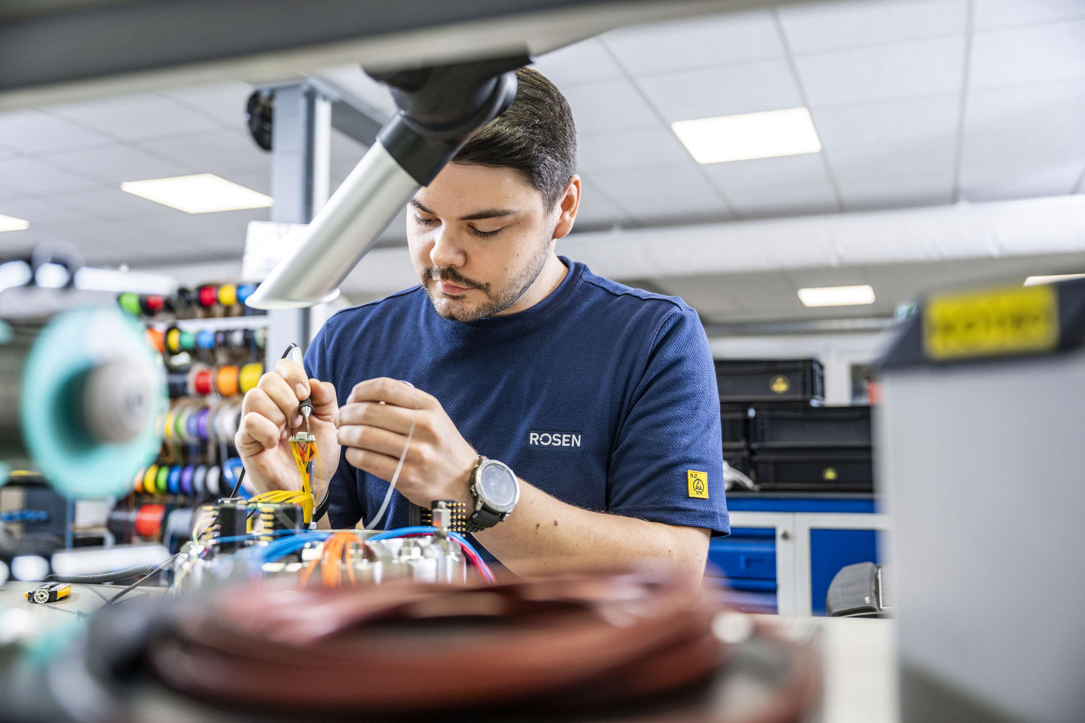 Ein Mann, der sich auf das Löten von Elektronik konzentriert.