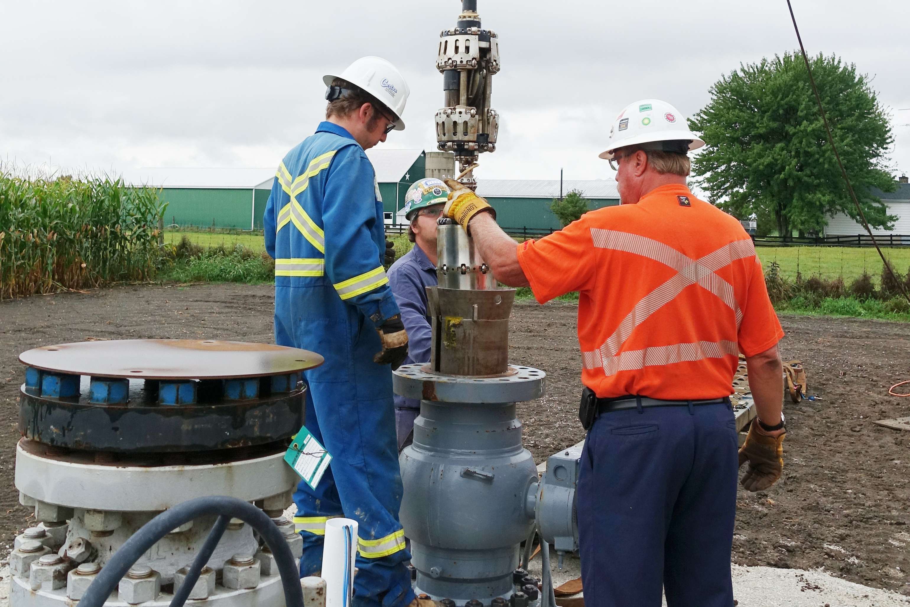 Workers inserting a tool vertically into the pipeline.