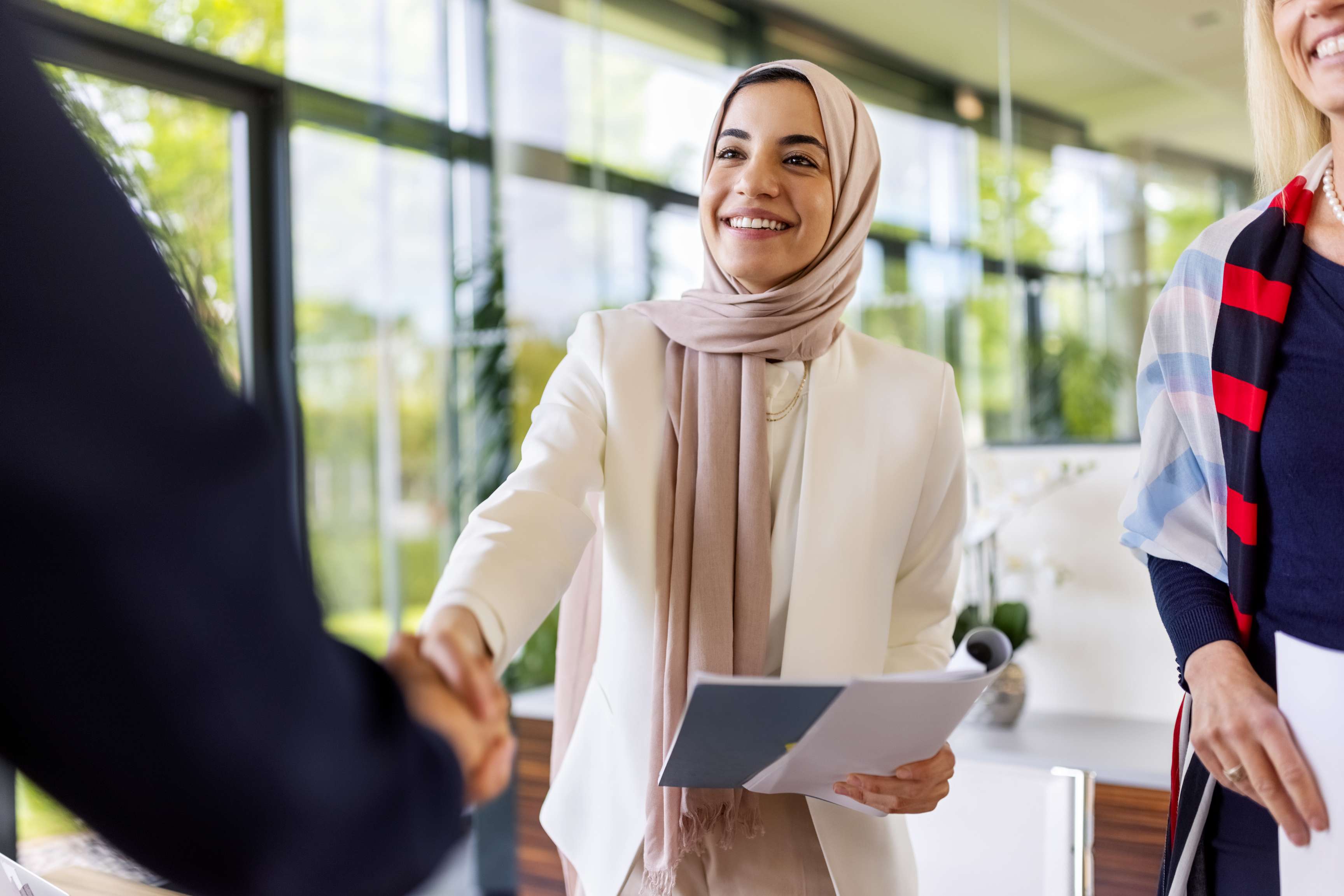 Young woman shaking hands with her new business partner after a successful deal.