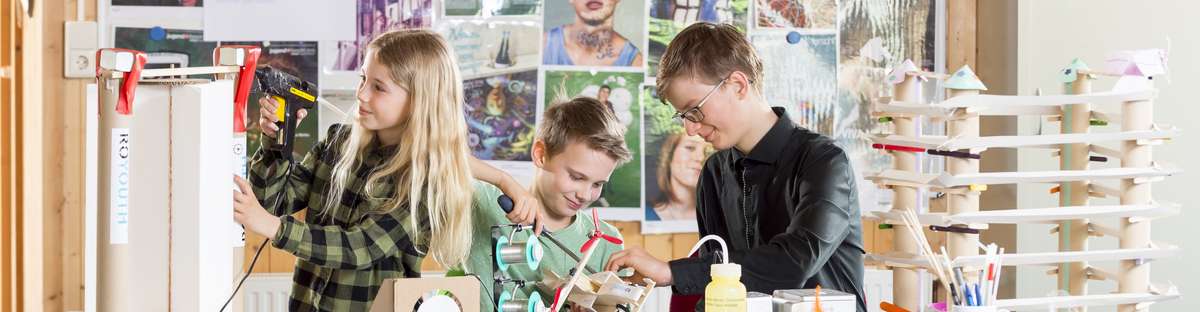 Three children conducting various experiments or making things at a table