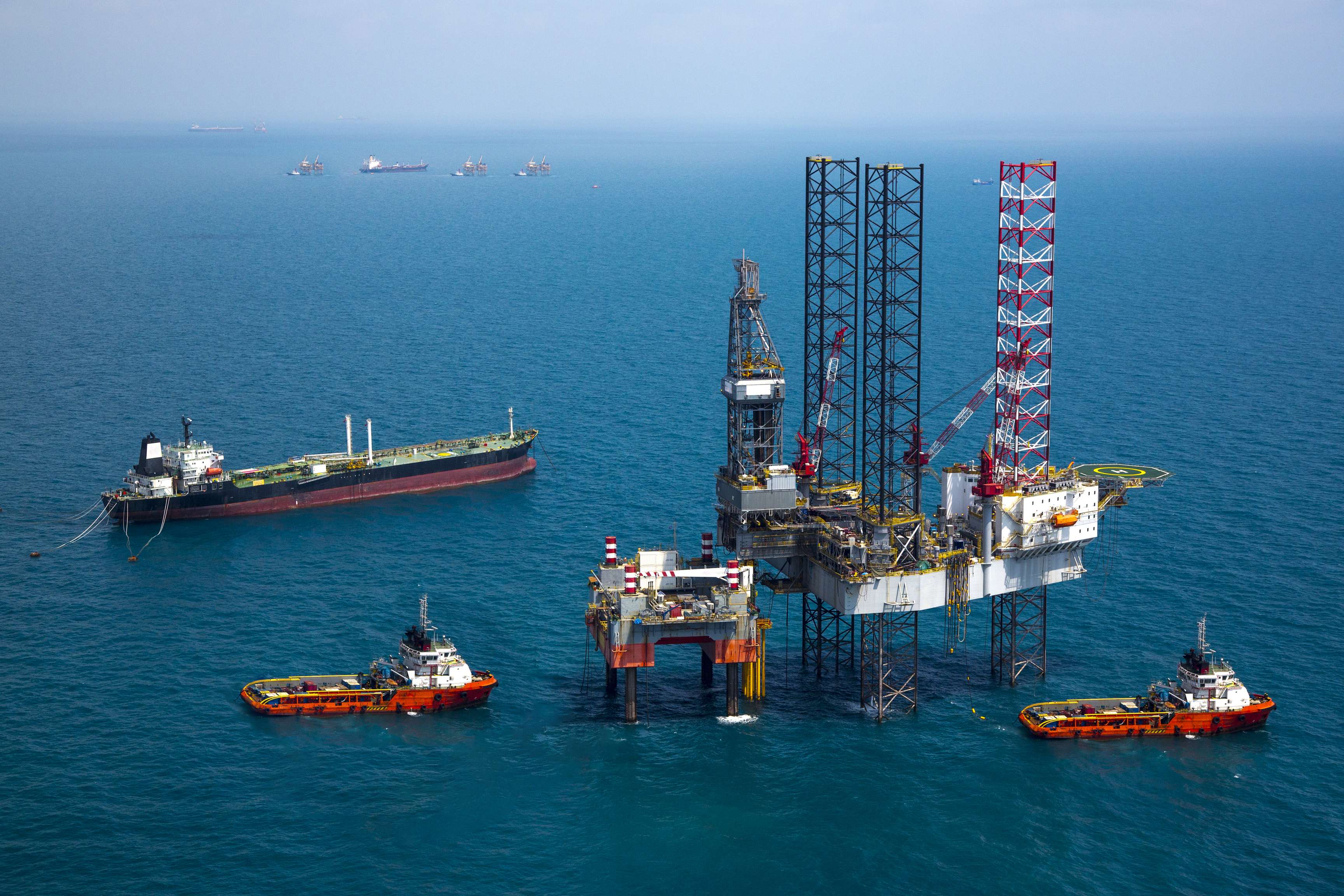 Offshore platform with tanker and other vessels surrounding it.