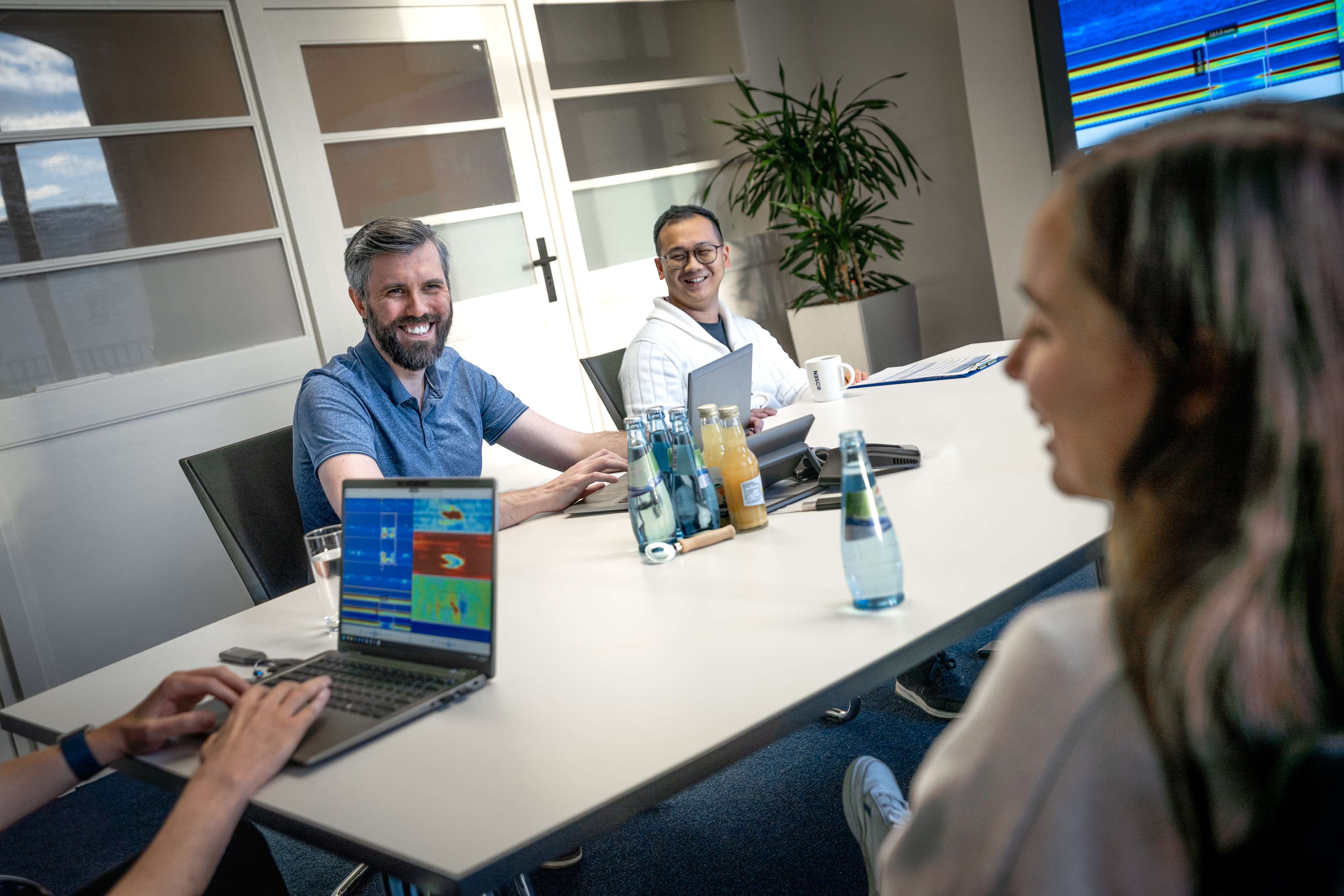 Group of ROSEN colleagues sitting in a meeting room and discussing data.