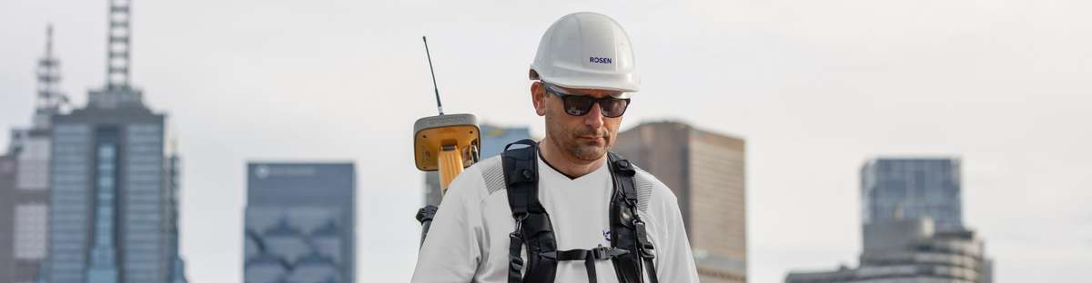 Ein Mitarbeiter von ROSEN führt eine Large-Stan-Off-Magnetometrie-Messung (LM) vor einer Skyline durch.