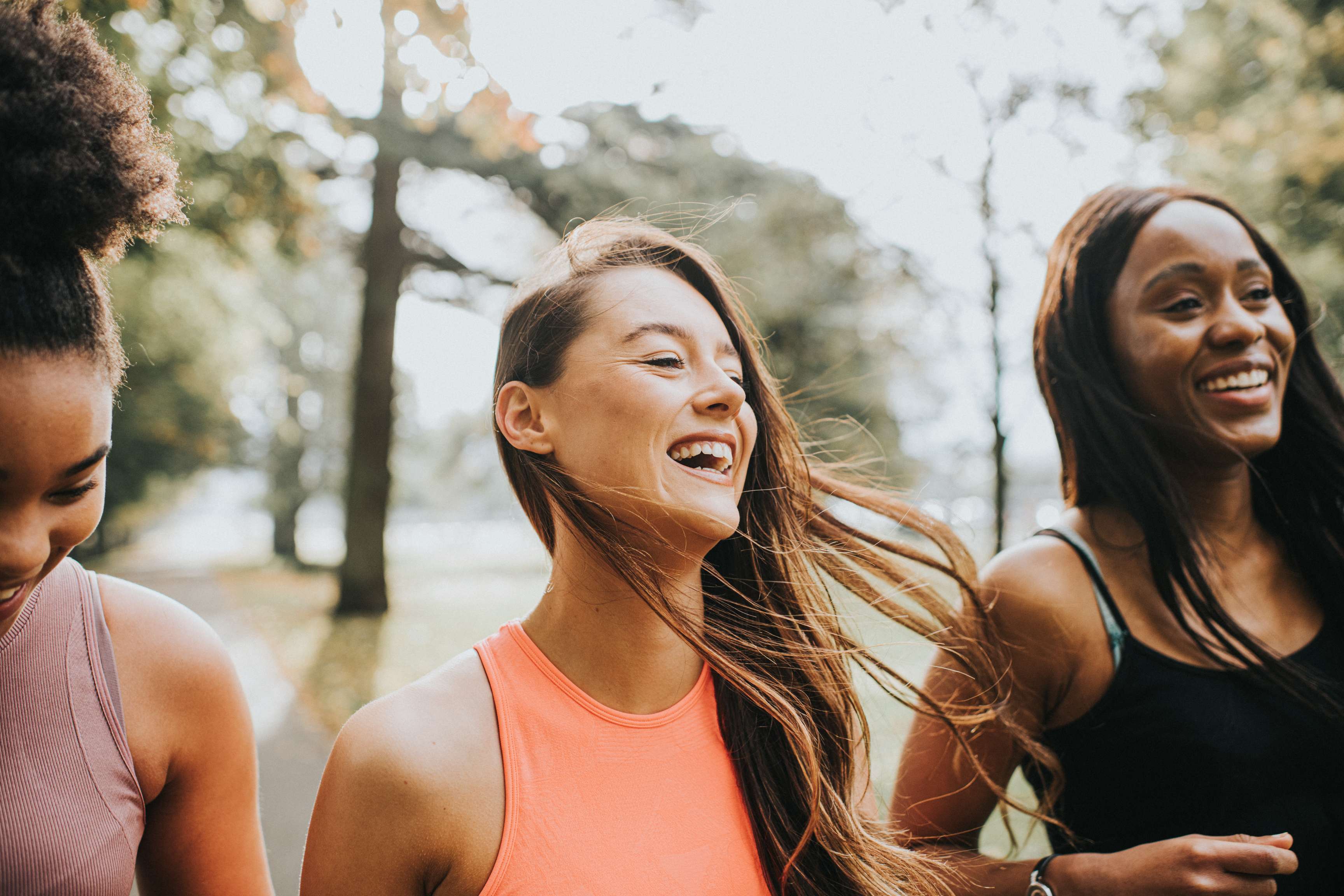 Three laughing women in sports outfits.