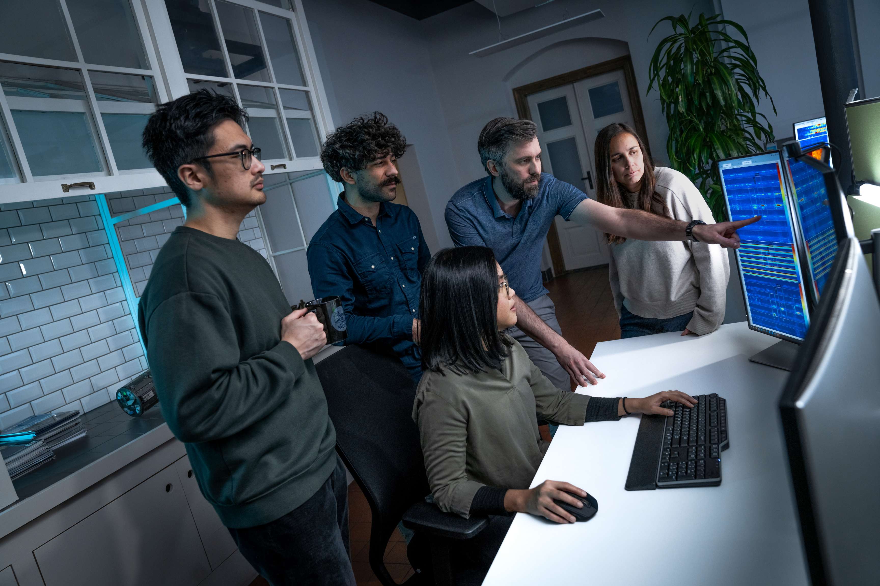 Group of ROSEN colleagues discussing data at a work desk.