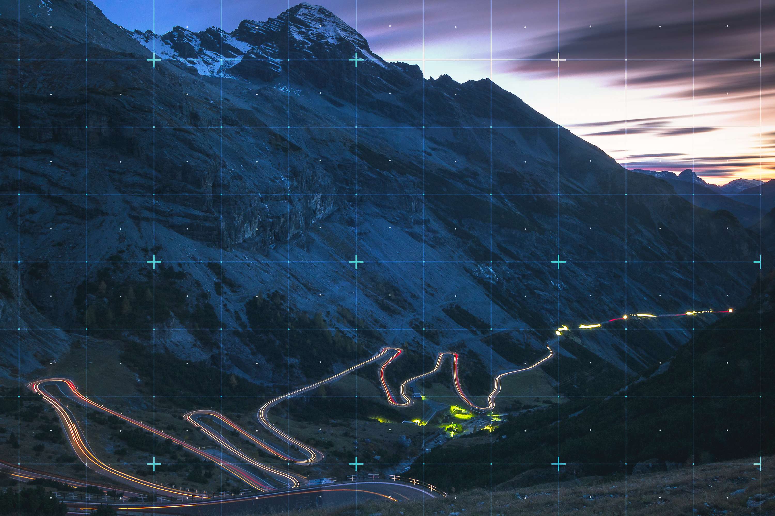 Rasterized view of dark mountain landscape with lighted road passing through it.