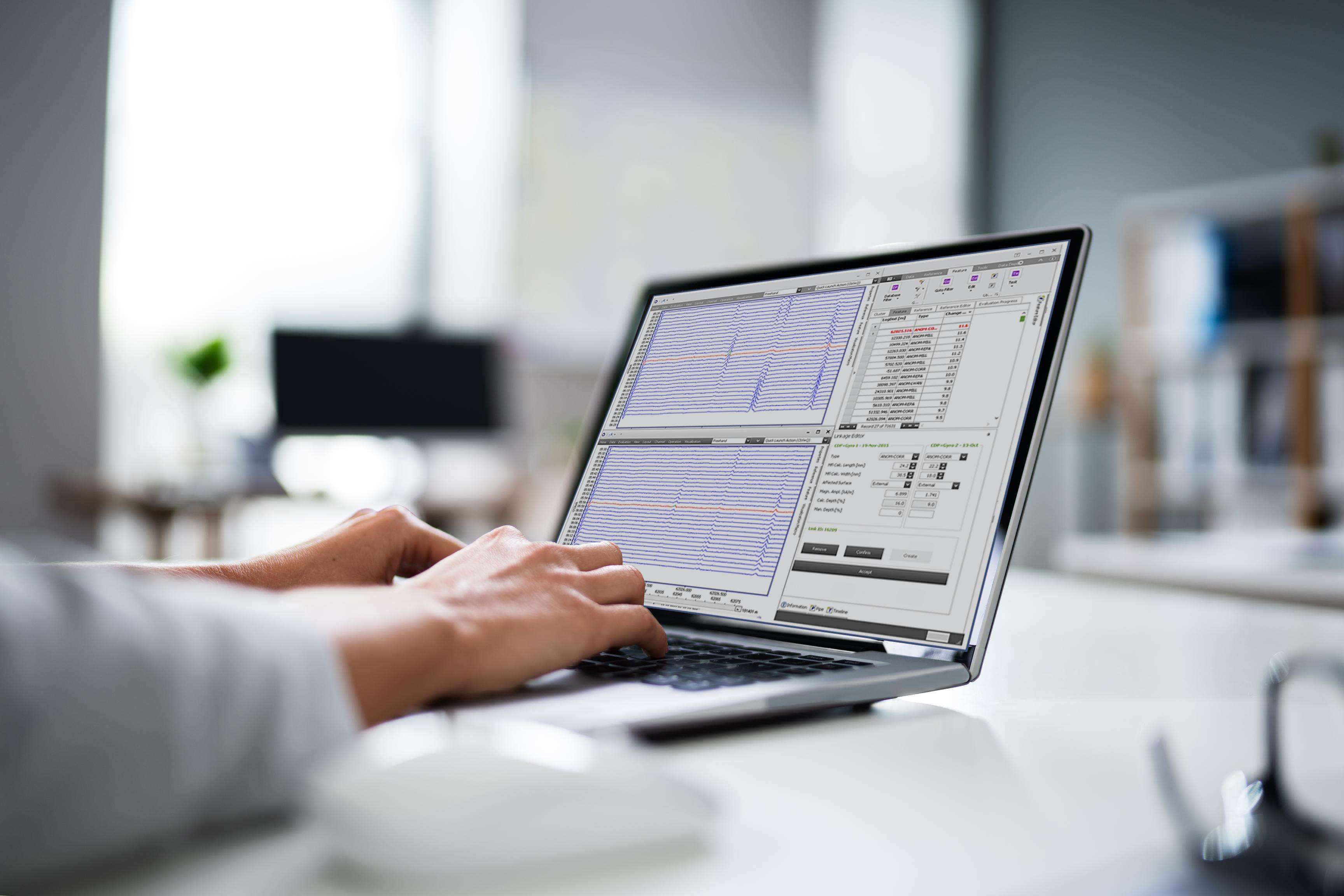 Person is sitting in front of a laptop that is standing sideways and on which a process template can be seen.