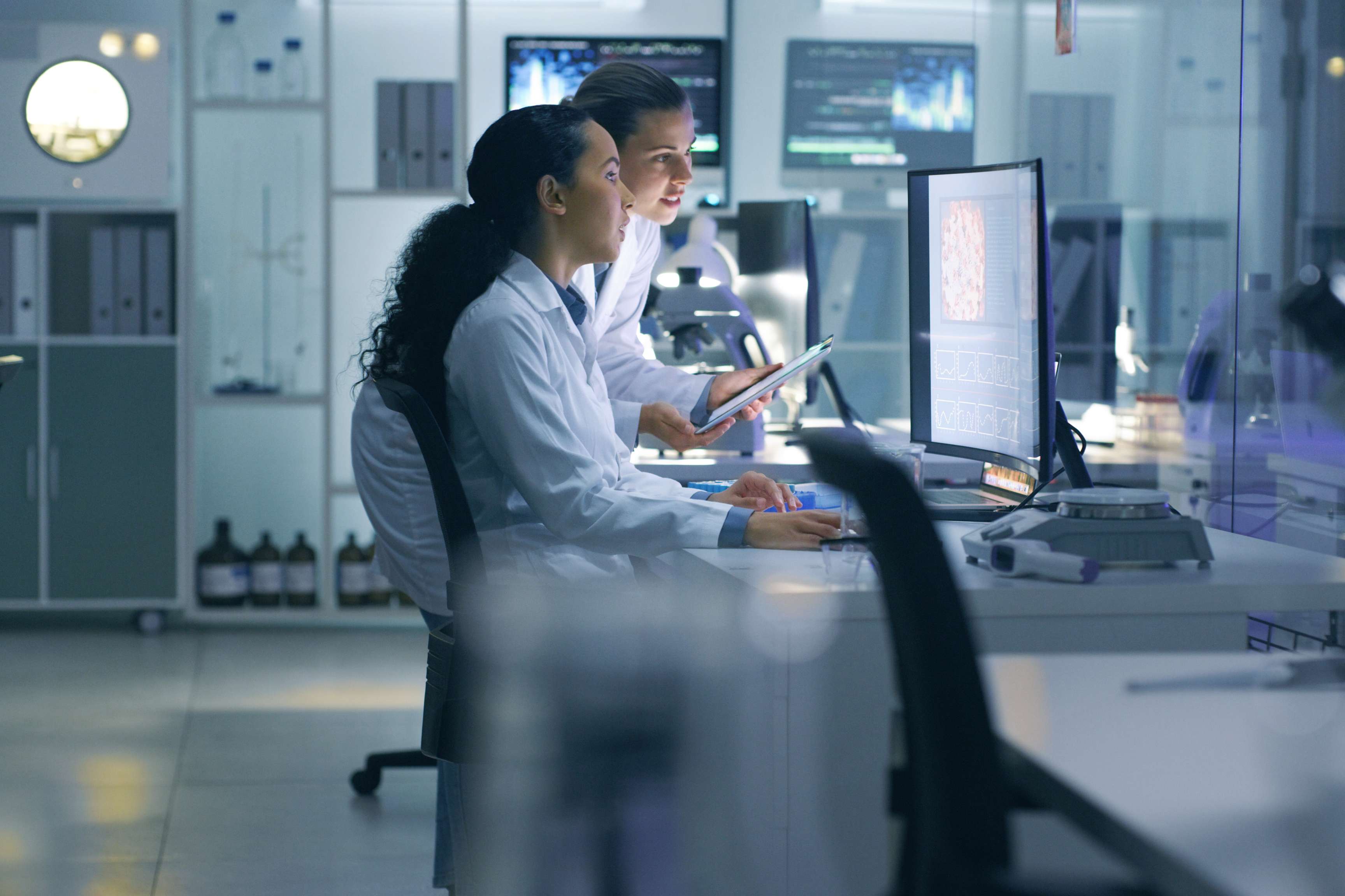 Employee looking at computer screen showing charts.