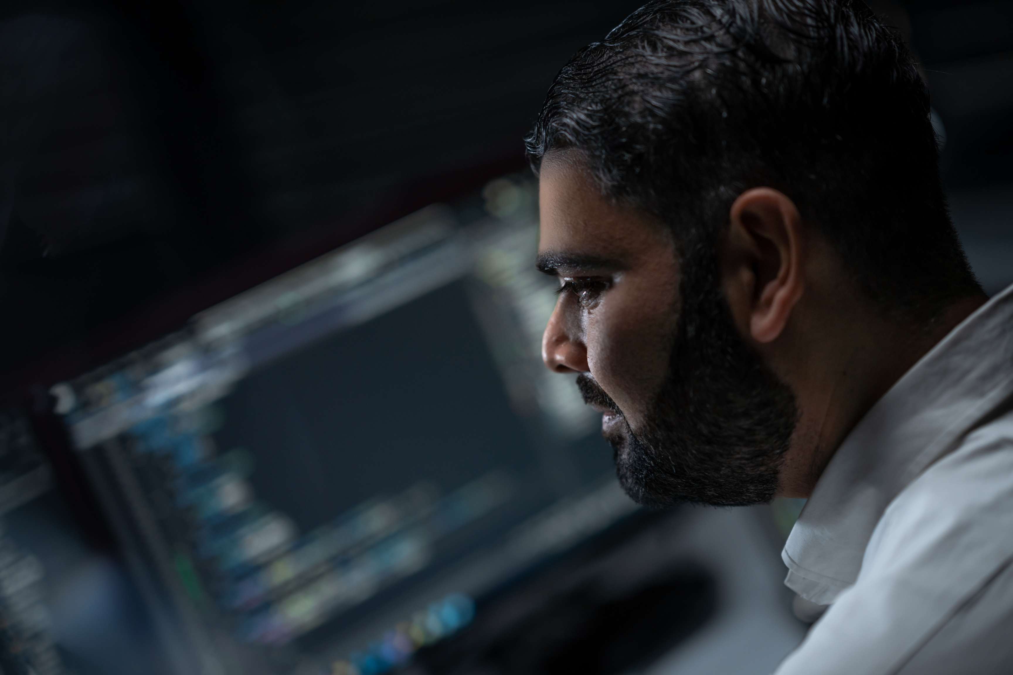 Ein Mann, der sich auf Bildschirme konzentriert, auf denen Daten angezeigt werden.