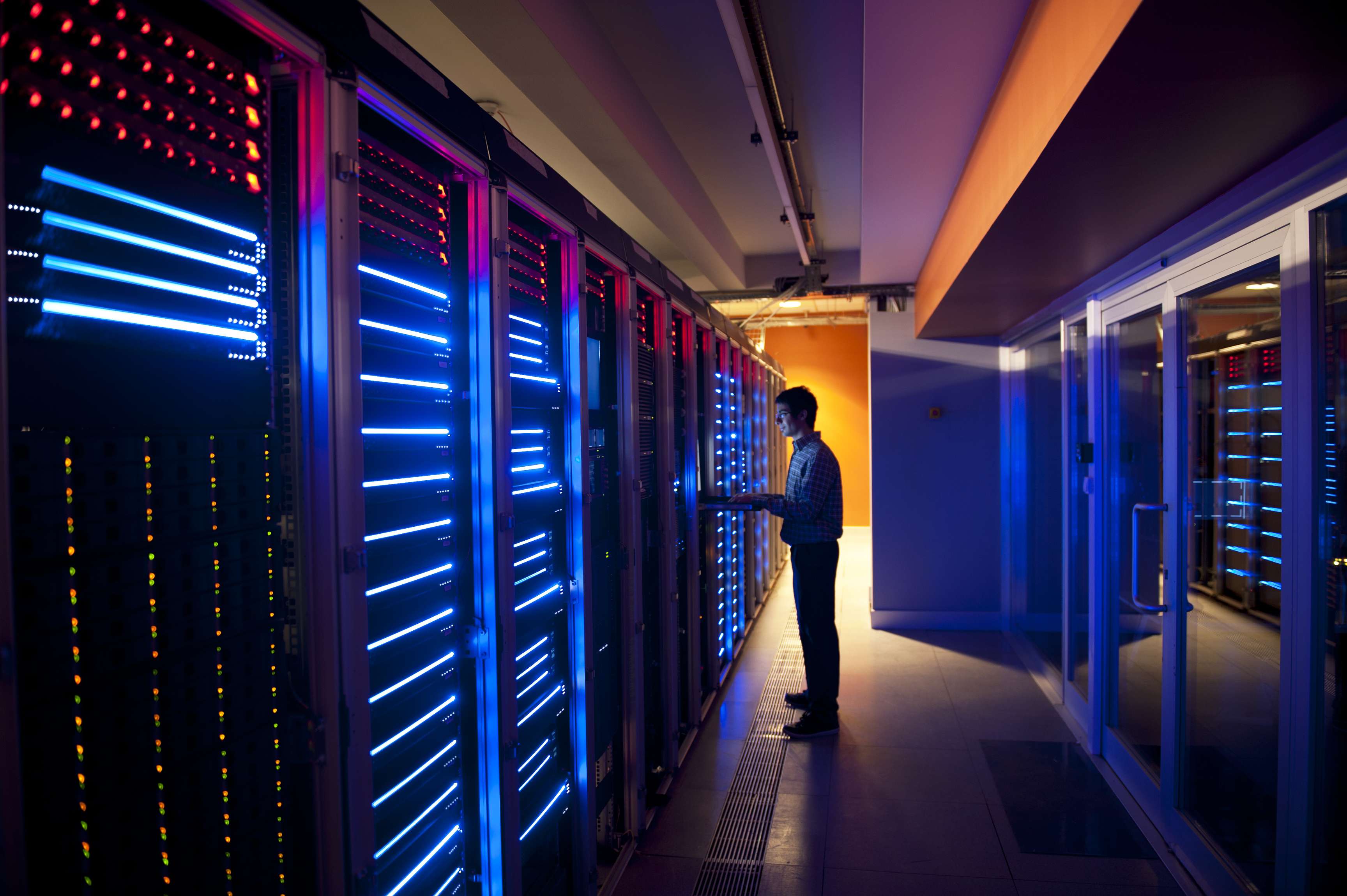 IT technician stands in a server room.